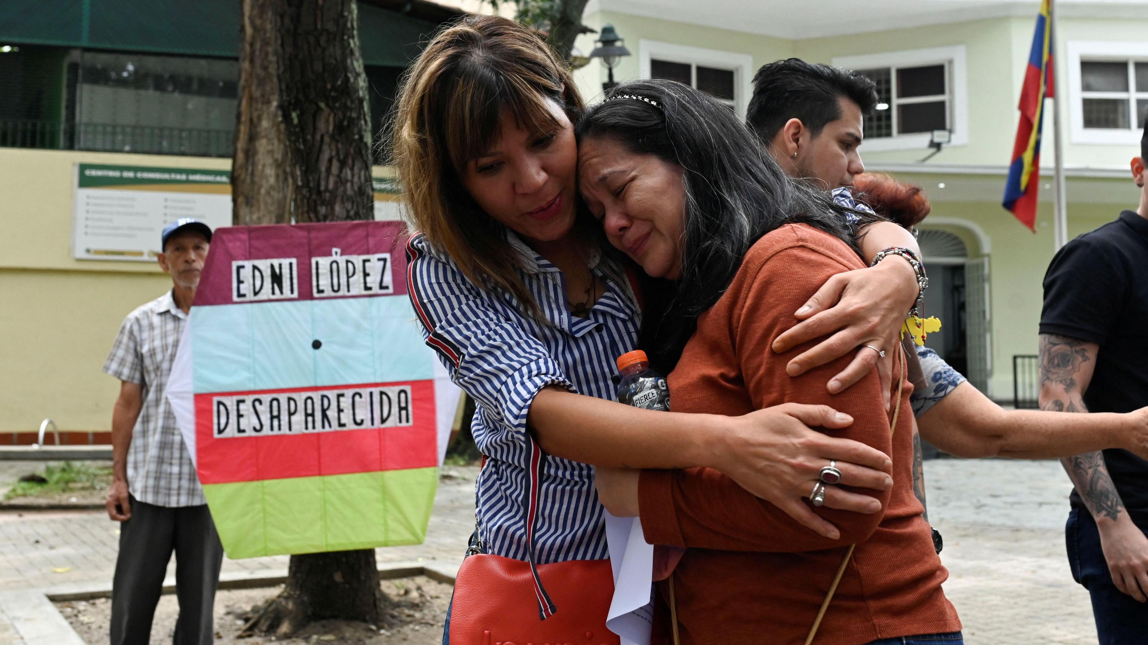 Ninoska Barrios, mother of Edni Lopez, a teacher for political science at the Central University of Venezuela and human rights activist, is being comforted after addressing the media about her daughter's disappearance