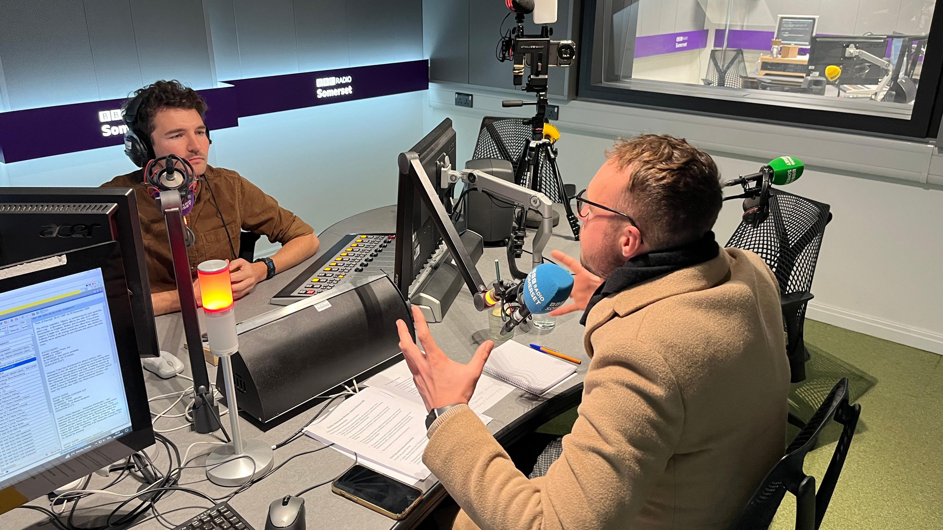 Charlie Taylor and Adam Dance in a BBC radio studio talking on air