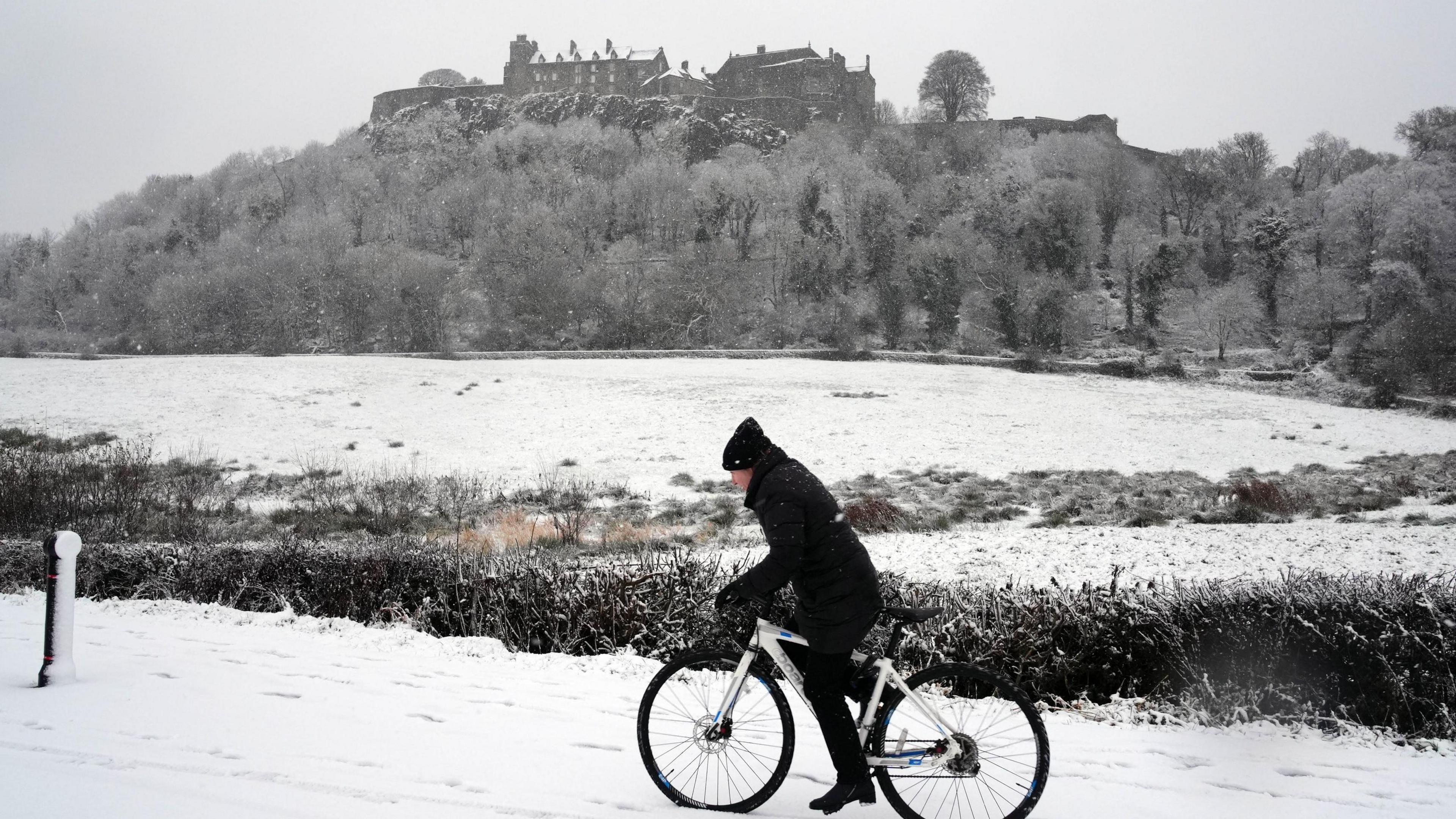 A person rides a bicycle in the snow at Stirling Castle, Stirling, Scotland. 