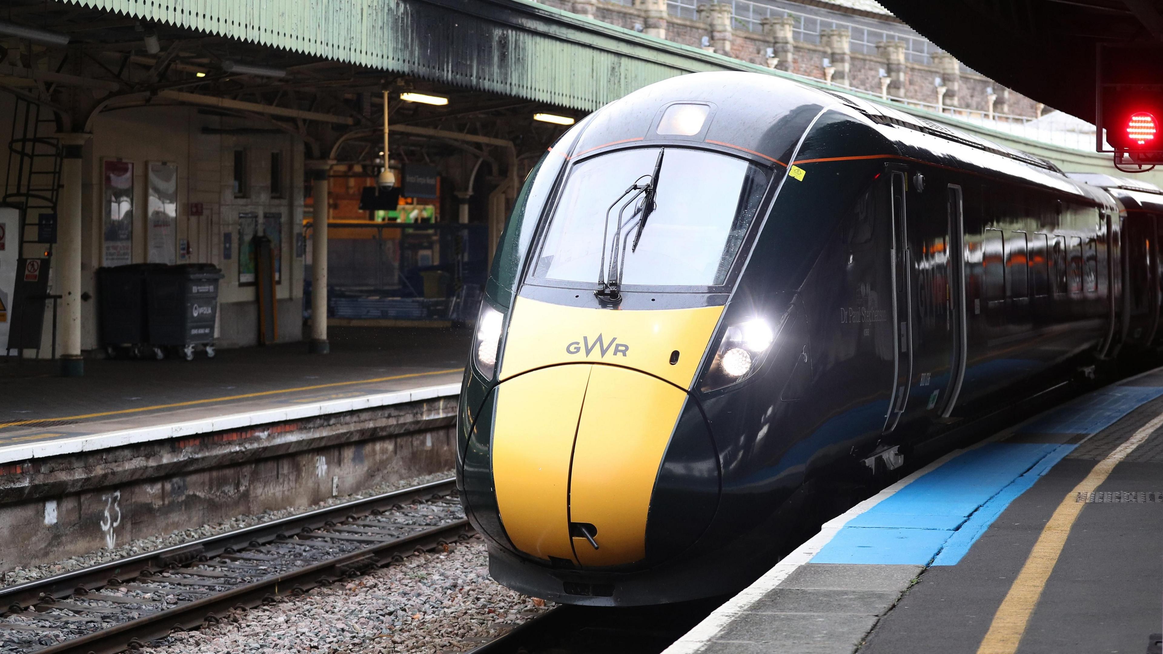 A Great Western Railway train is driving into Bristol Temple Meads. It is dark green with a yellow front.