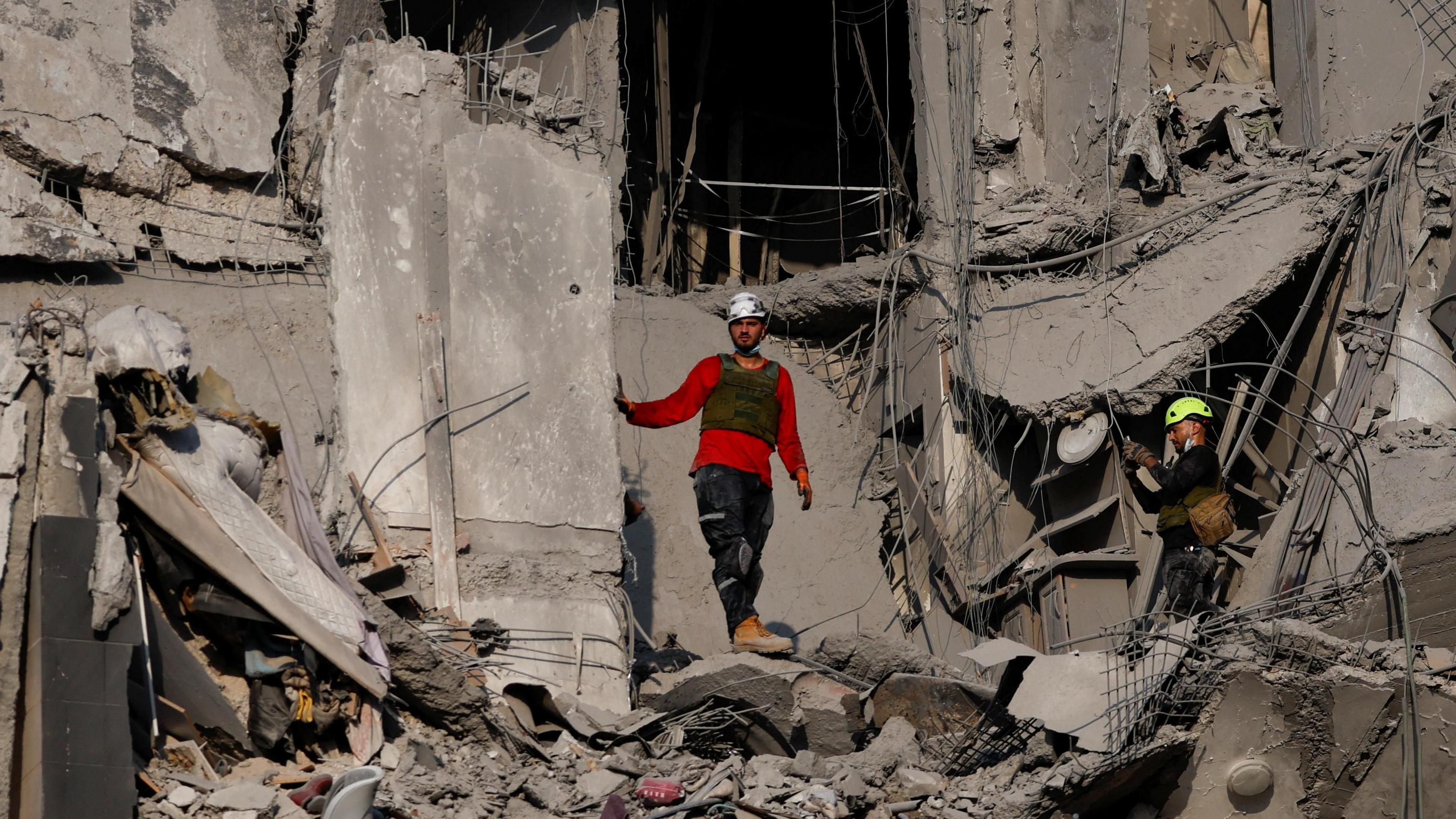 Emergency services stand in rubble and debris in Israel following a missile attack from Iran