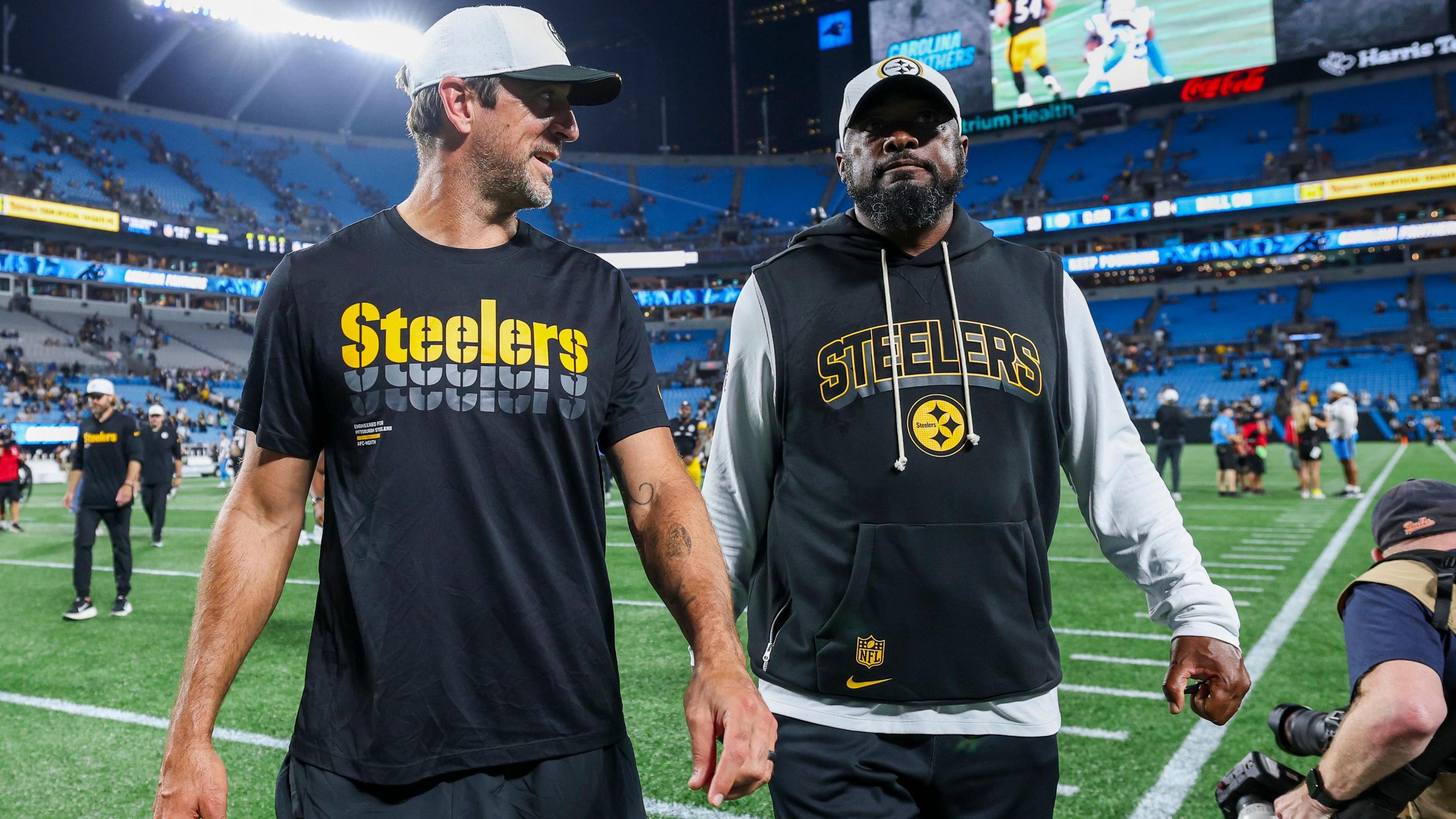 Quarterback Aaron Rodgers and head coach Mike Tomlin of the Pittsburgh Steelers walk off the field following a pre-season game
