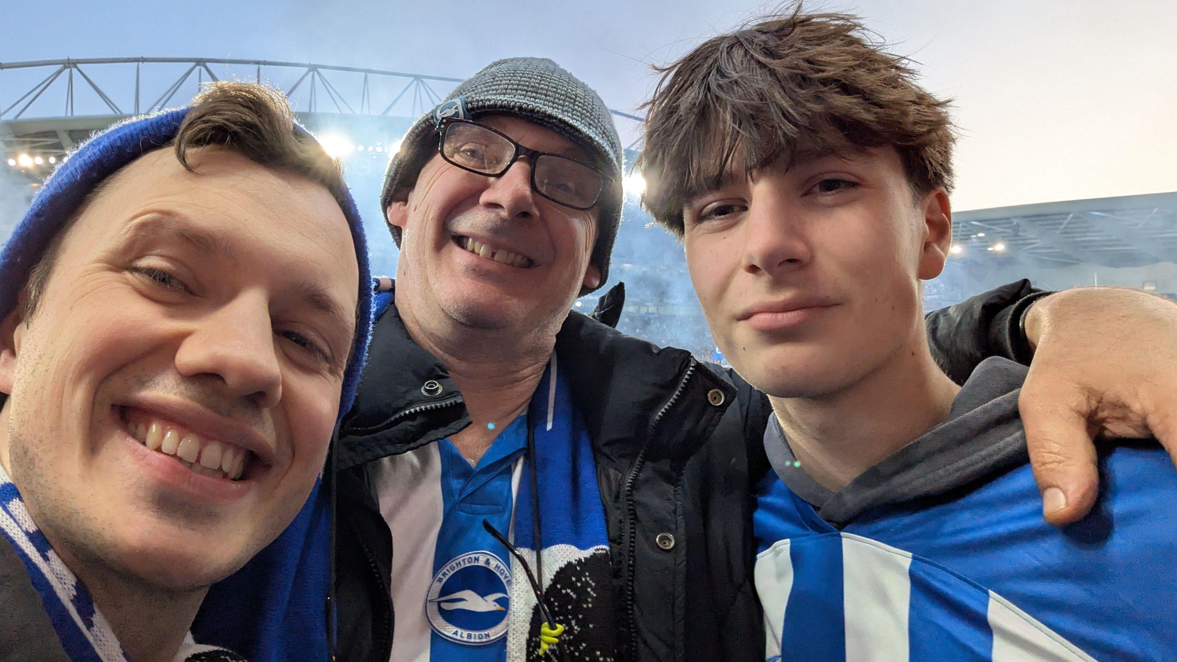 A man in a hat and his two seasons take a selfie at Amex Stadium