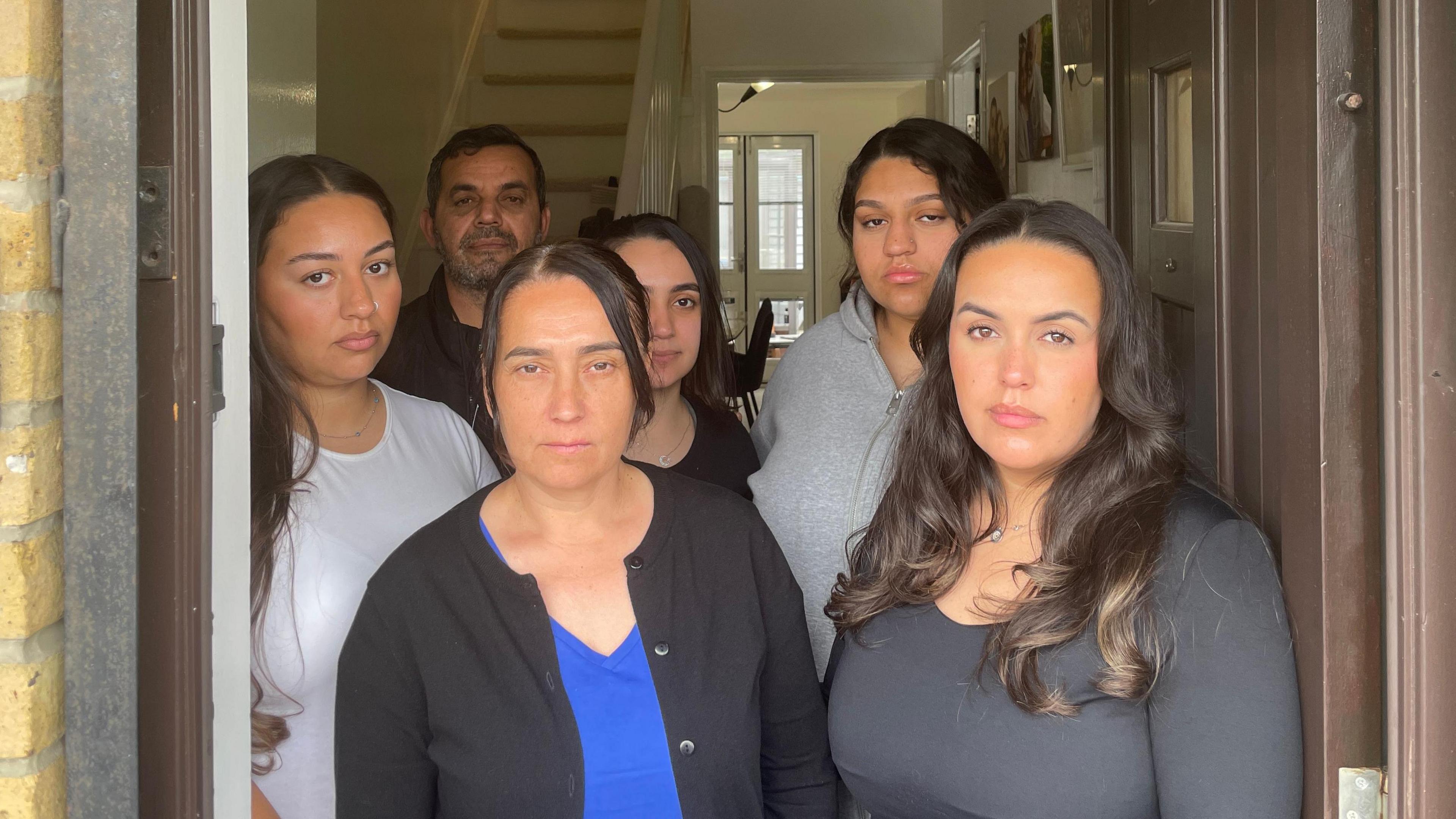 Dilara, her father Ecevit, and family pictured in the doorway of their home