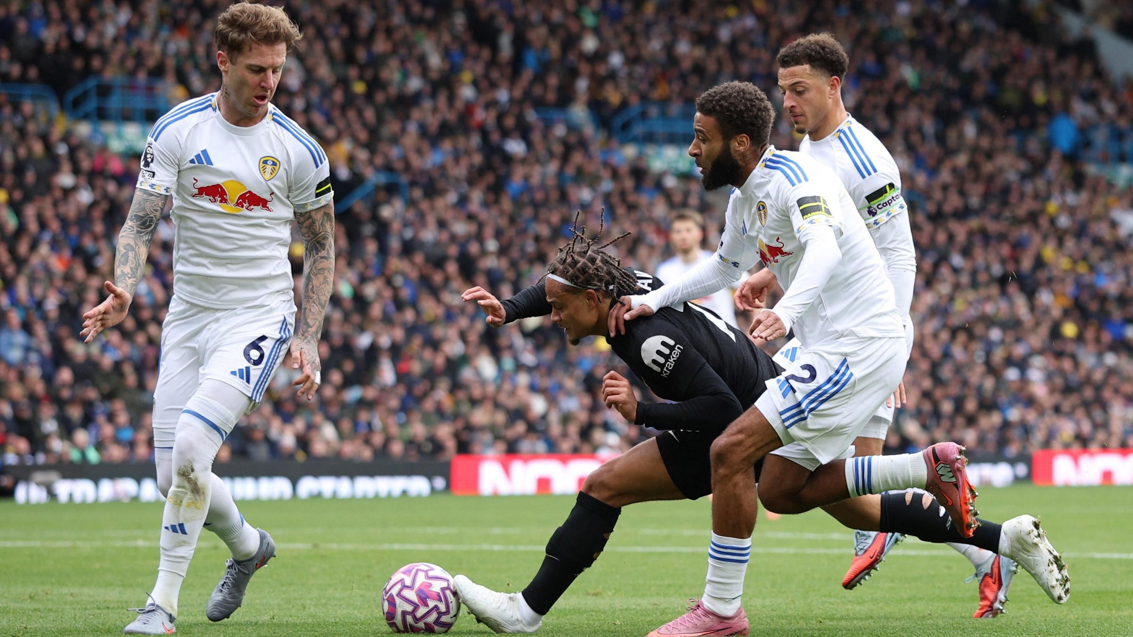 Leeds United's Joe Rodon, Jayden Bogle and Ethan Ampadu in action with Tottenham Hotspur's Xavi Simons 