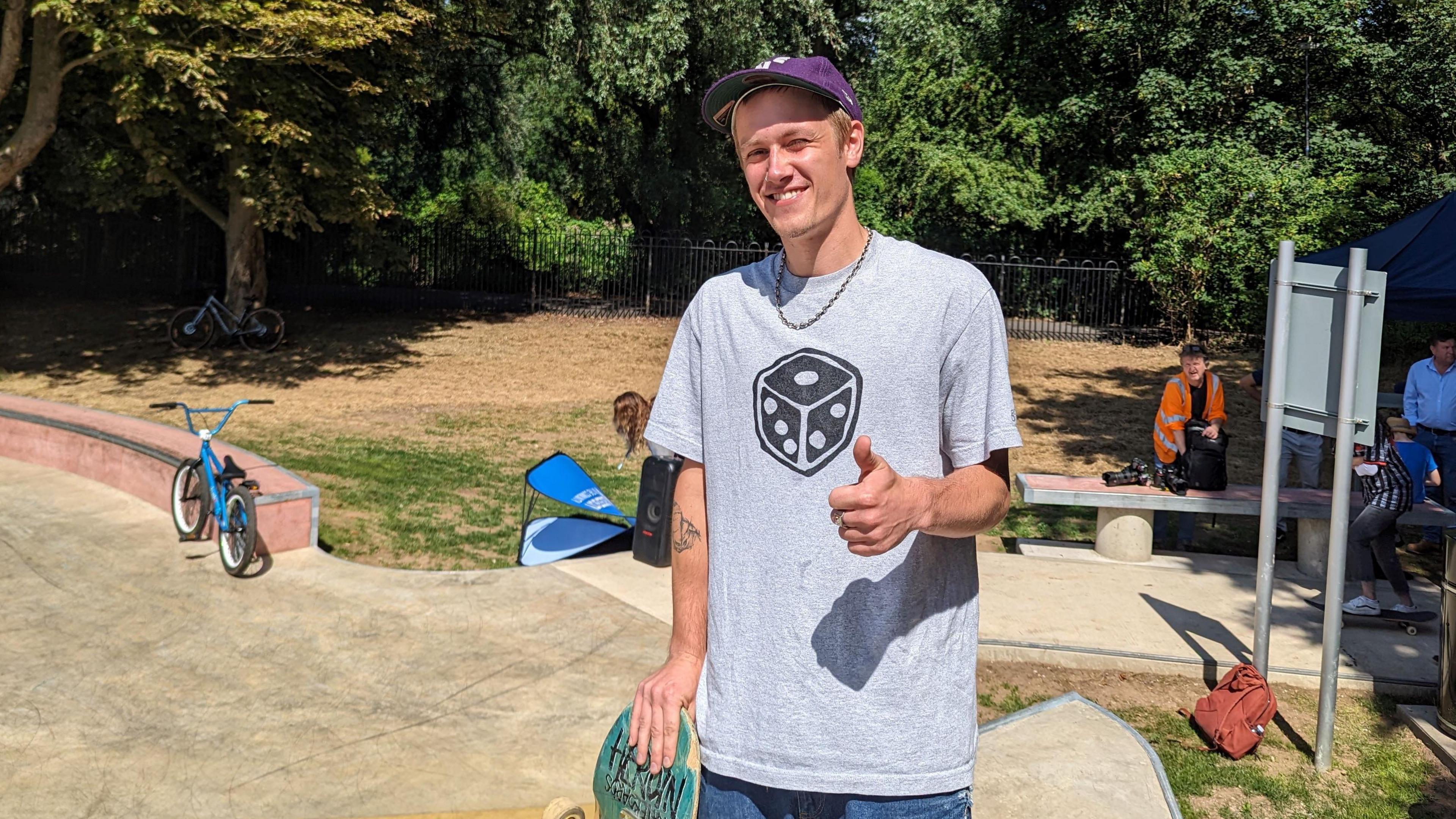 Will Simpson stood with a skateboard, wearing a baseball cap at the new facility in St Margaret's Pastures sports ground