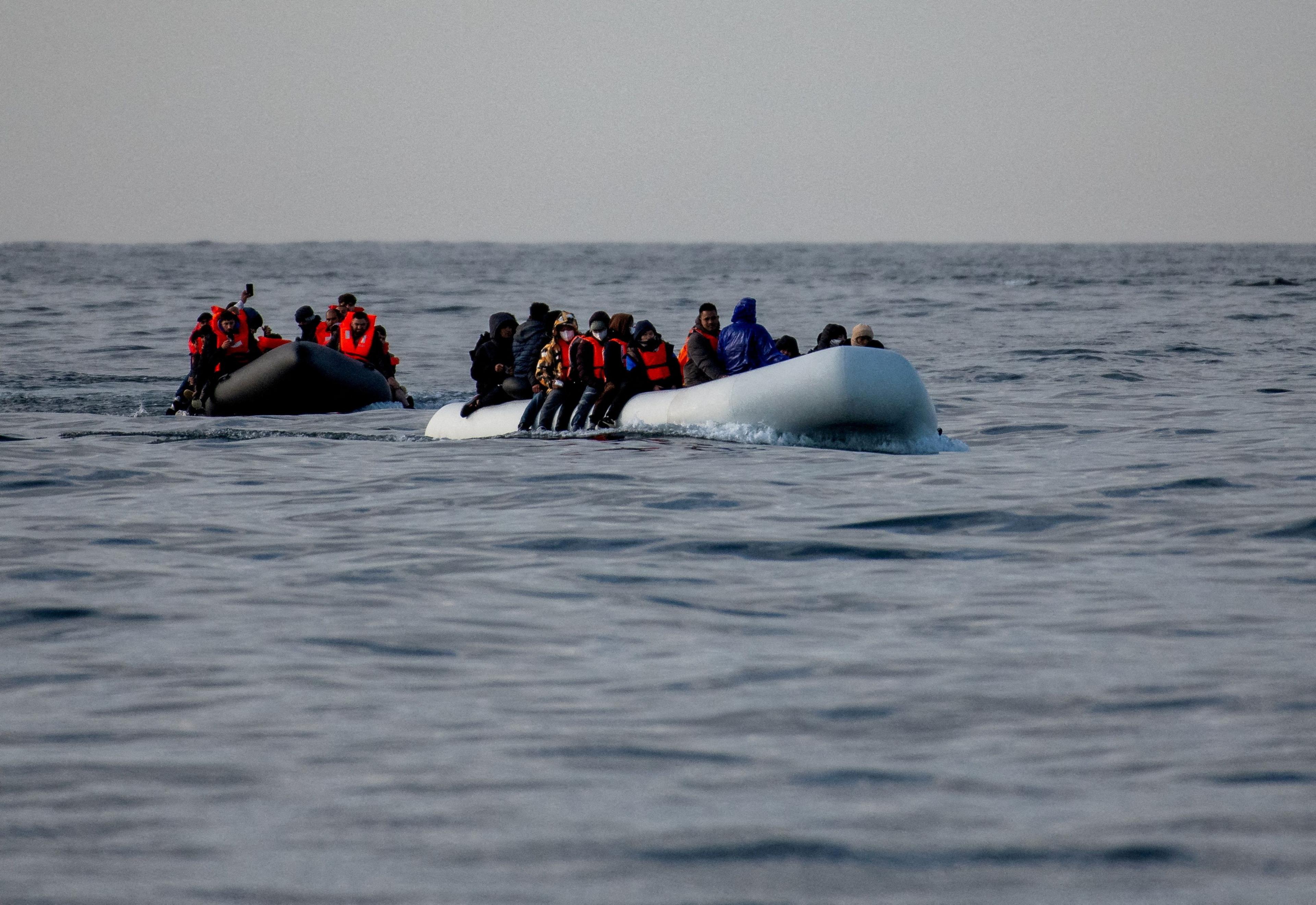 Boats filled with people wearing lifejackets