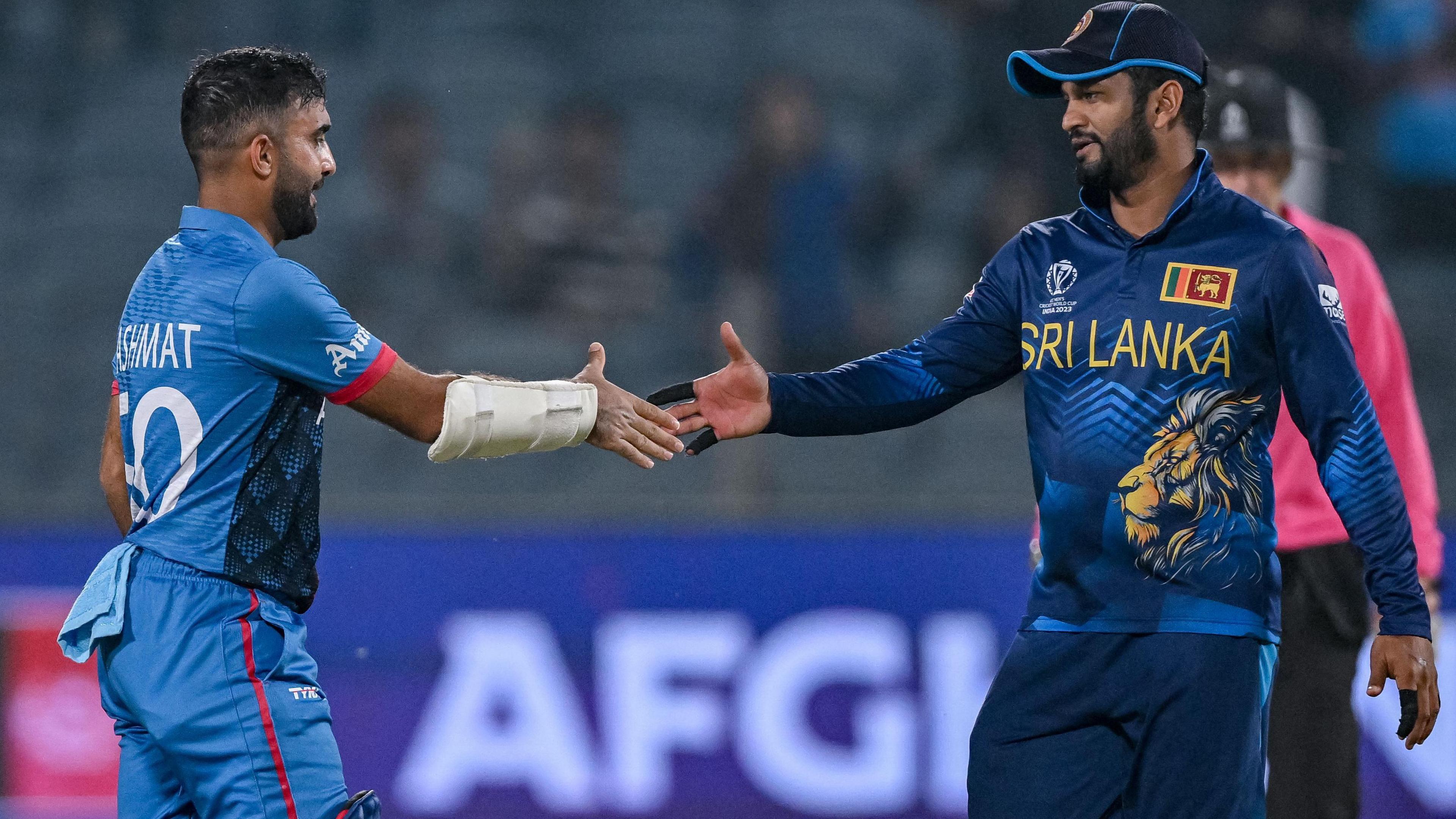 Afghanistan's Hashmatullah Shahidi and Sri Lanka's Dimuth Karunaratne shake hands at the 2023 World Cup