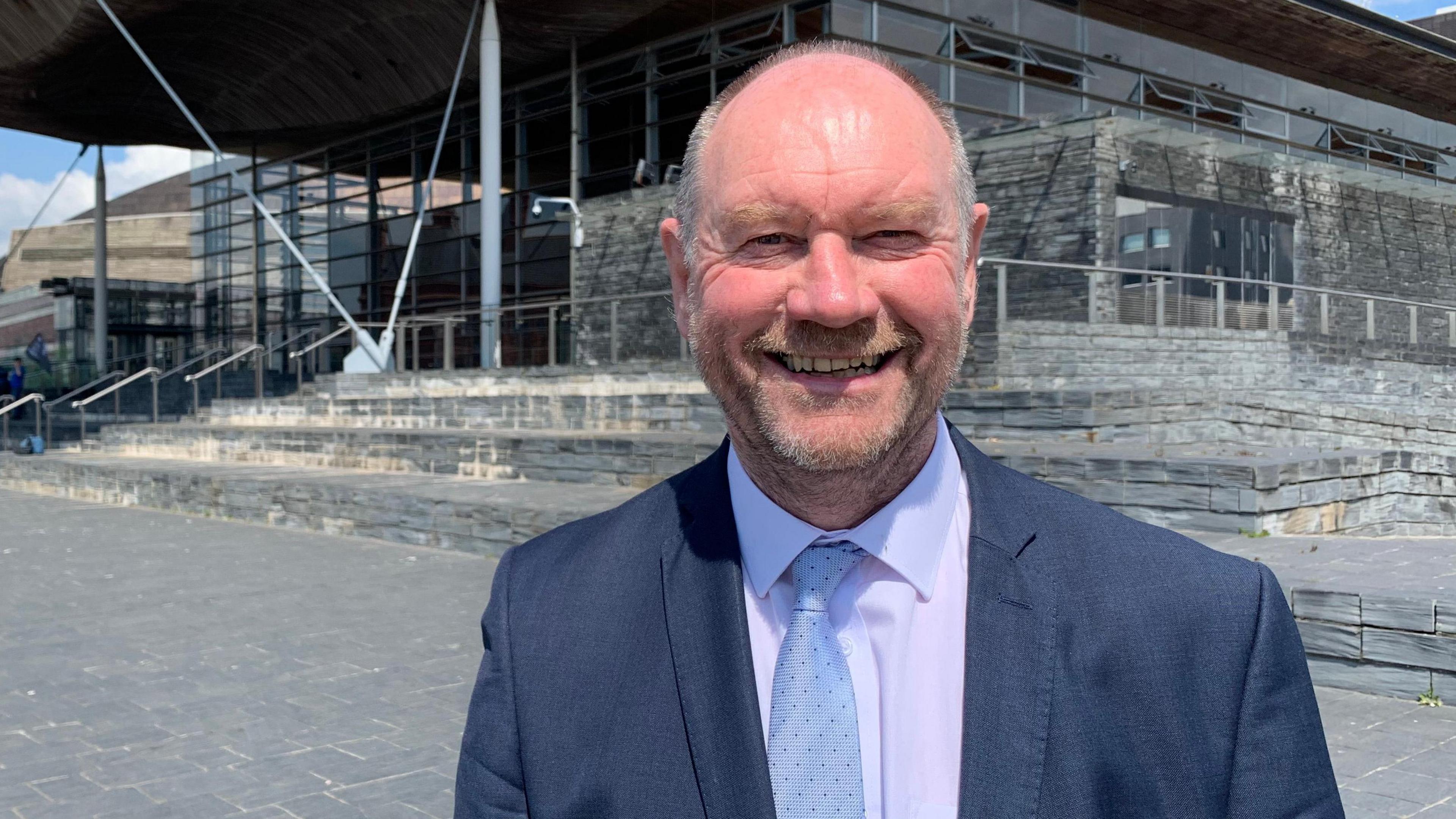 Cefin Campbell o flaen adeilad Senedd Cymru