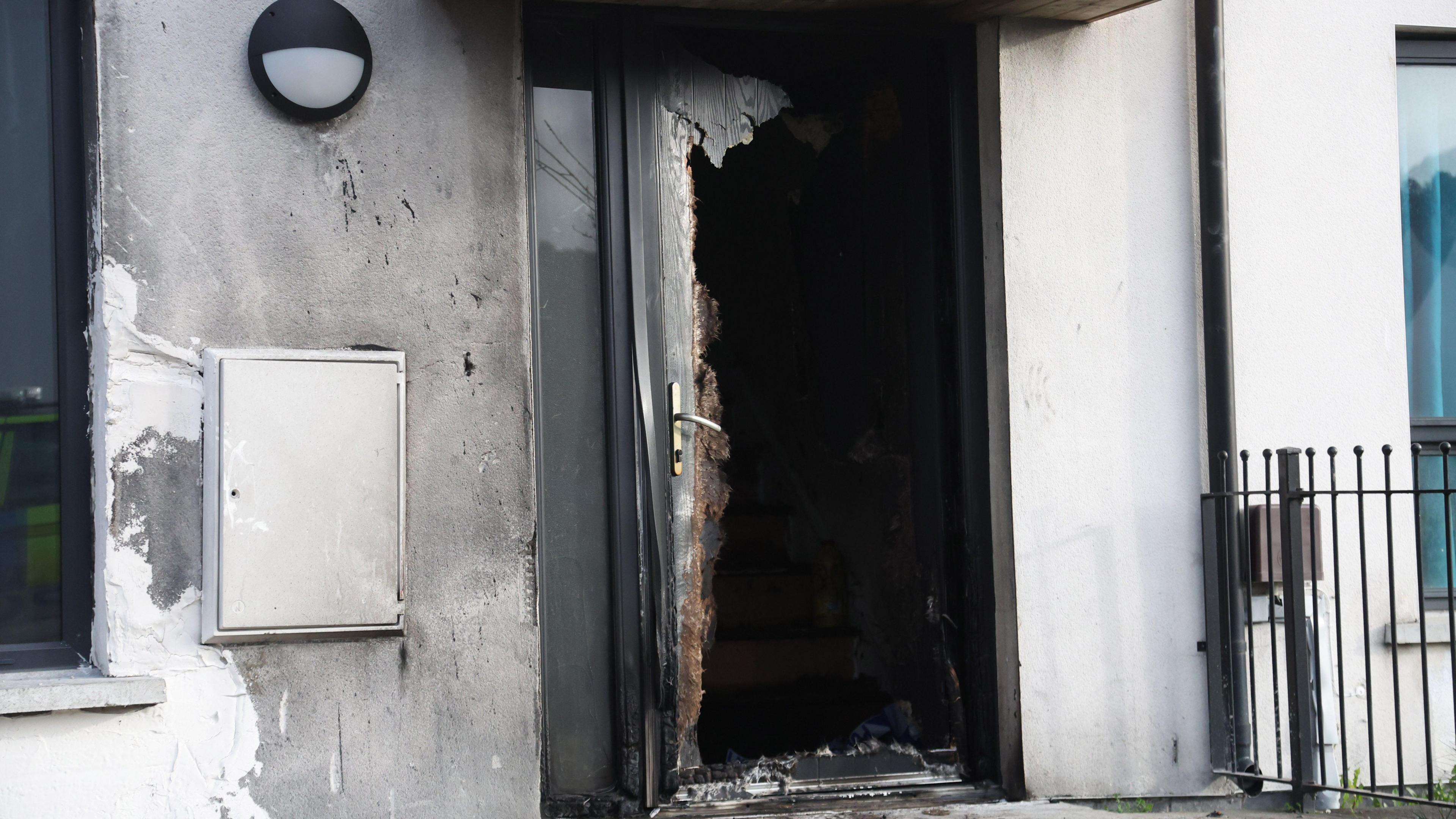 Close up of door of a house in Weaver's Grange in Newtownards which has been extensively damaged in a fire. There is also smoke damage on the wall to the left of the door