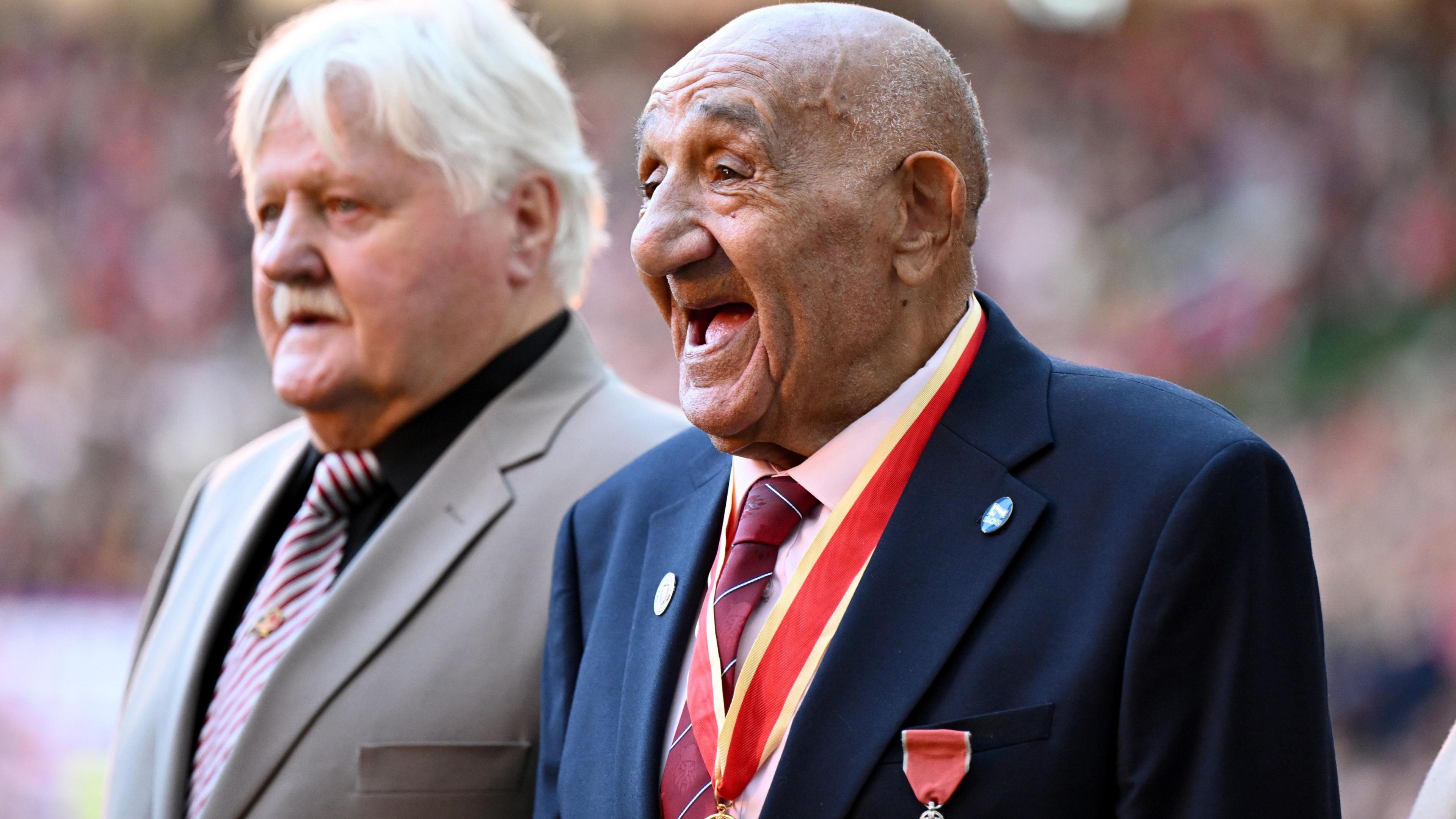 Sir Billy Boston looks to his right with a big smile on his face