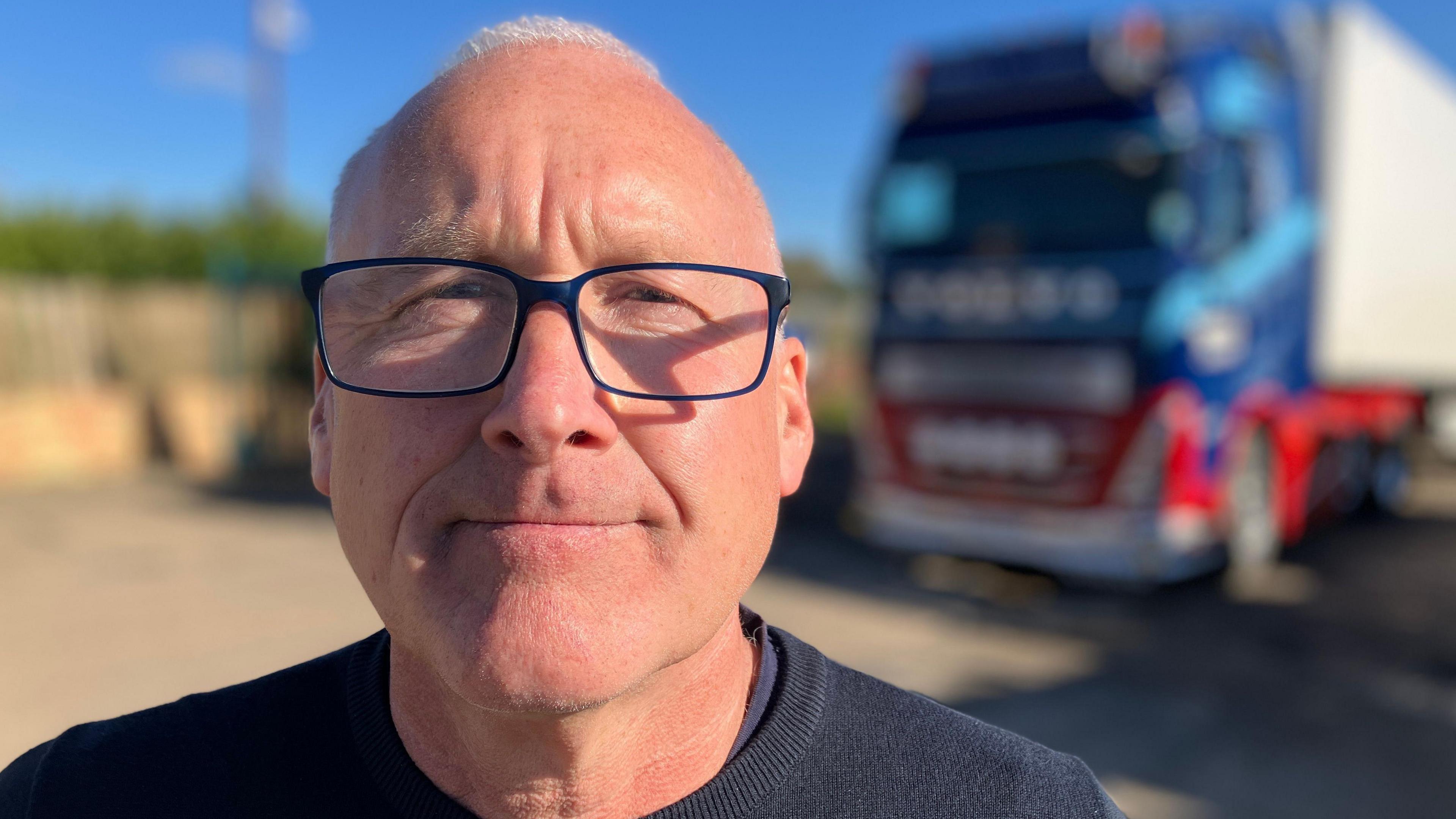 Haulier Trevor Rowell standing next to one of his trucks.