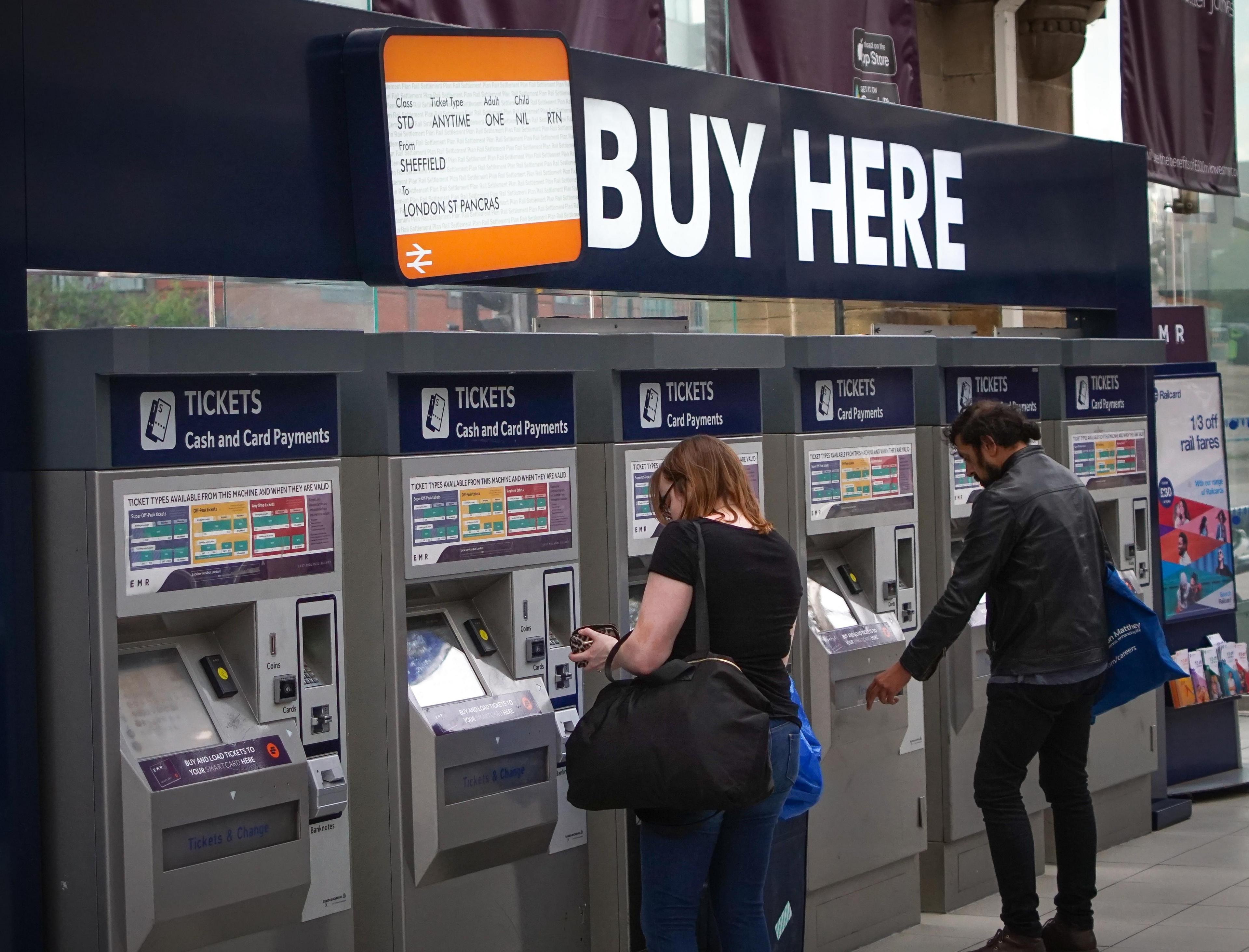 People buy train tickets at a machine