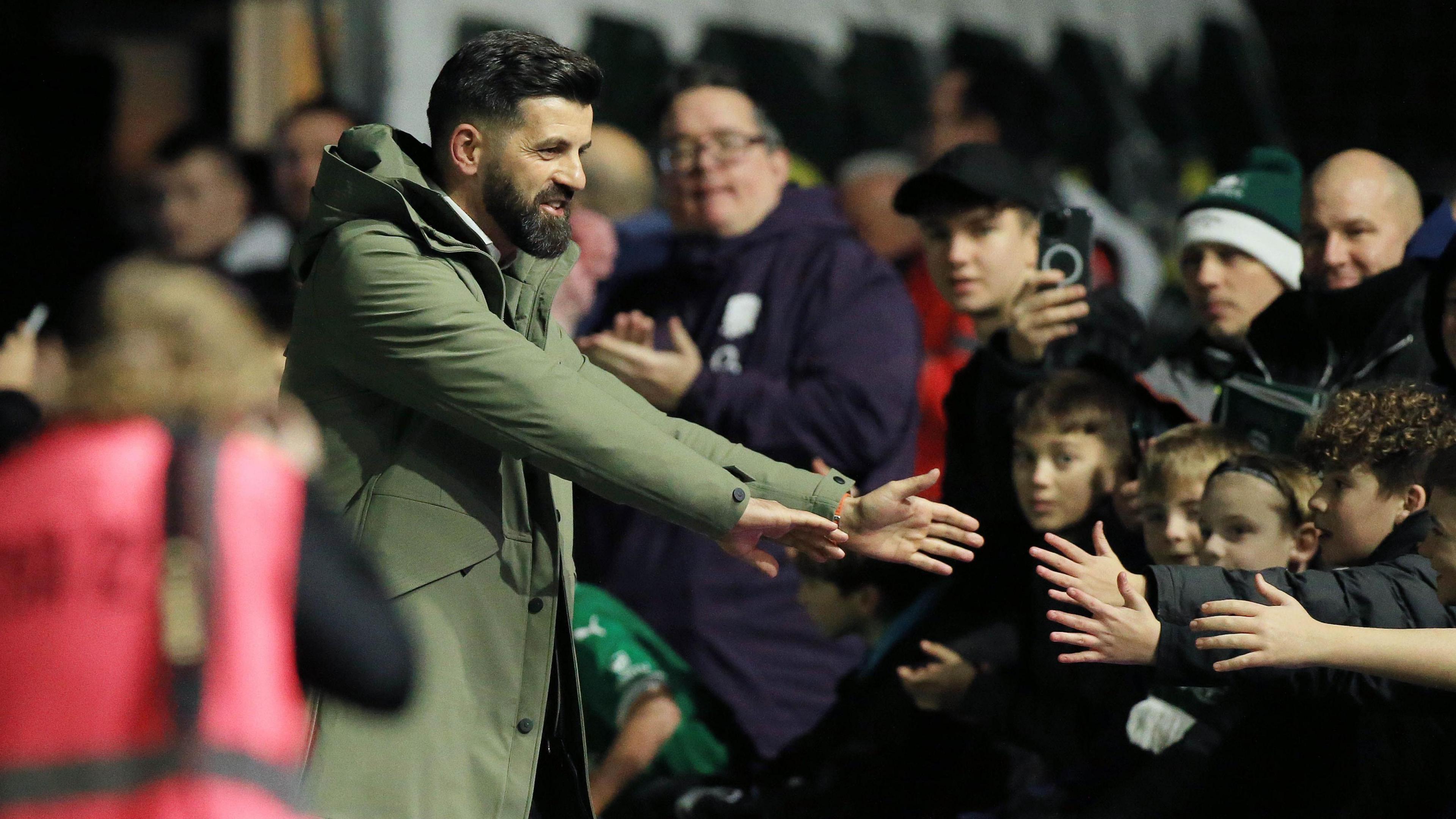 Miron Muslic holds his hands out to Plymouth fans