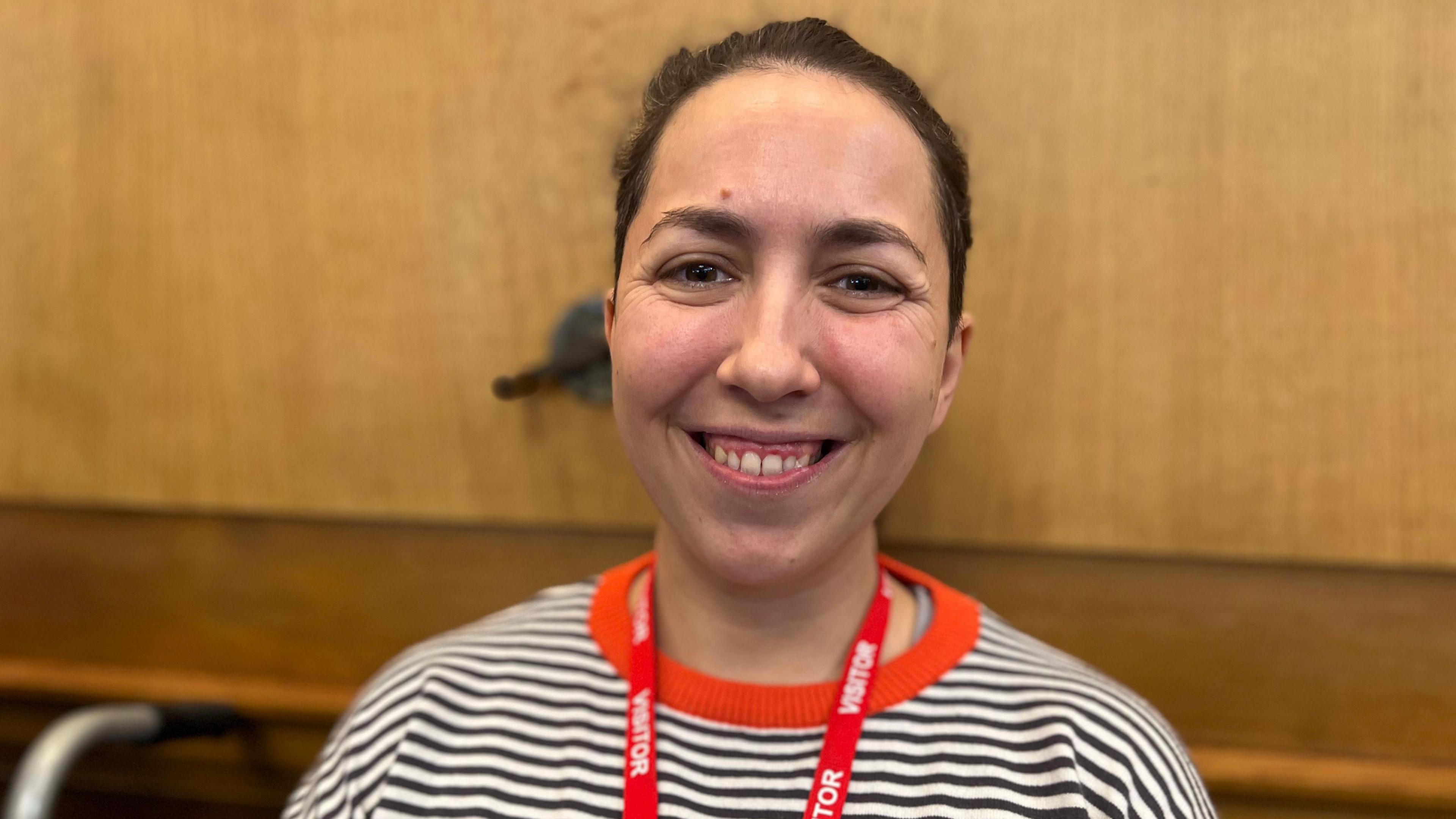 Woman in stripy top with black hair and red lanyard