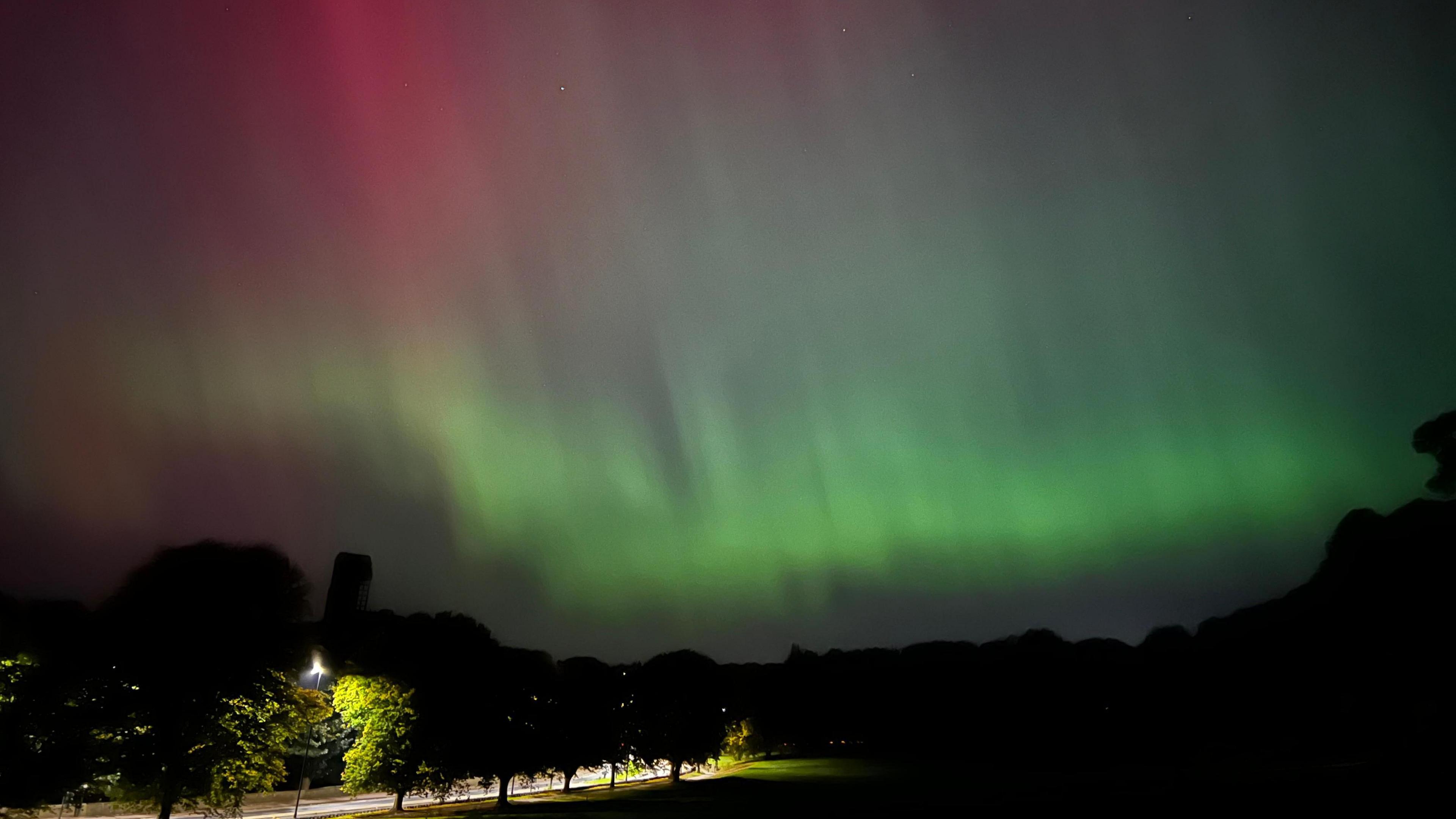 Green Northern Lights above a park.