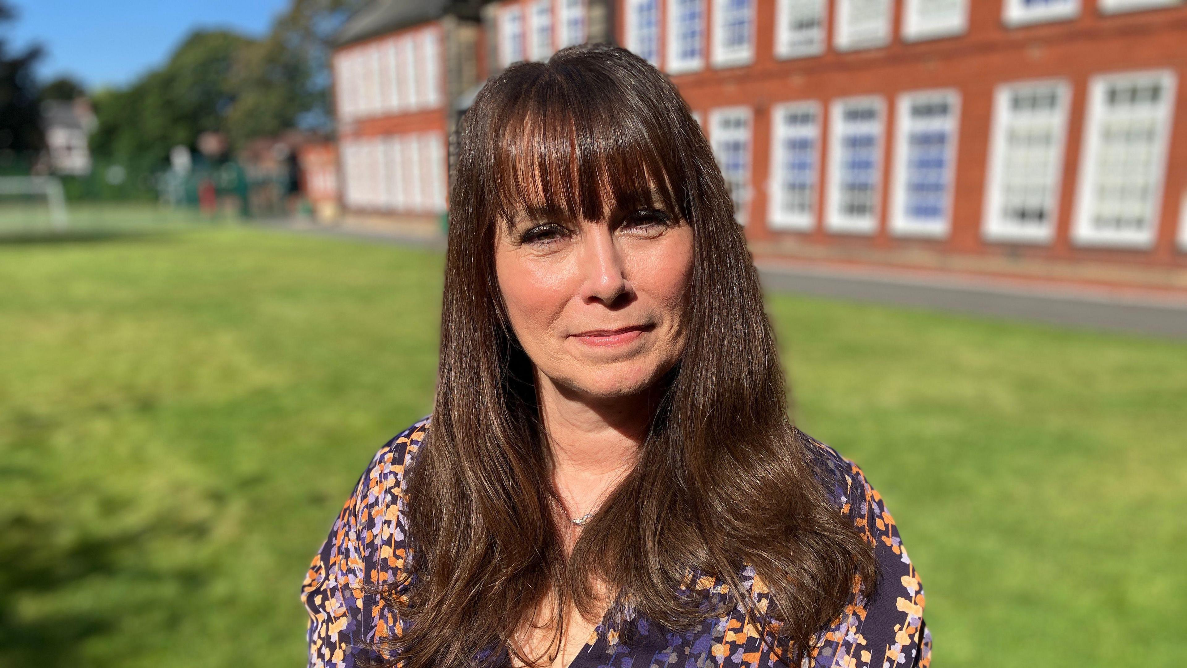 Rachel smiles for a photograph in the grounds outside Hulme Hall independent school