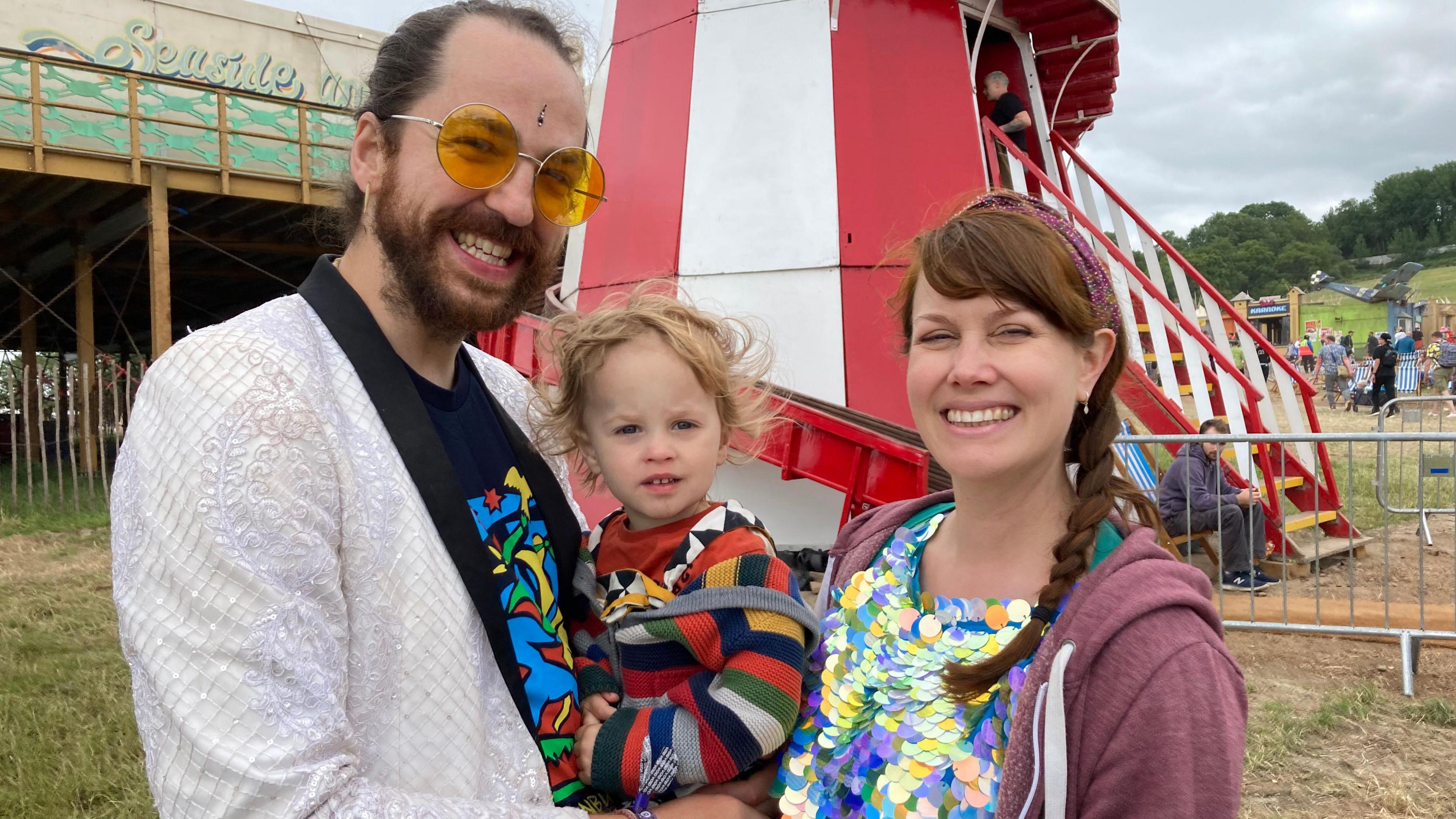 Dan Glastonbury is holding is son whilst standing next to his wife Emily