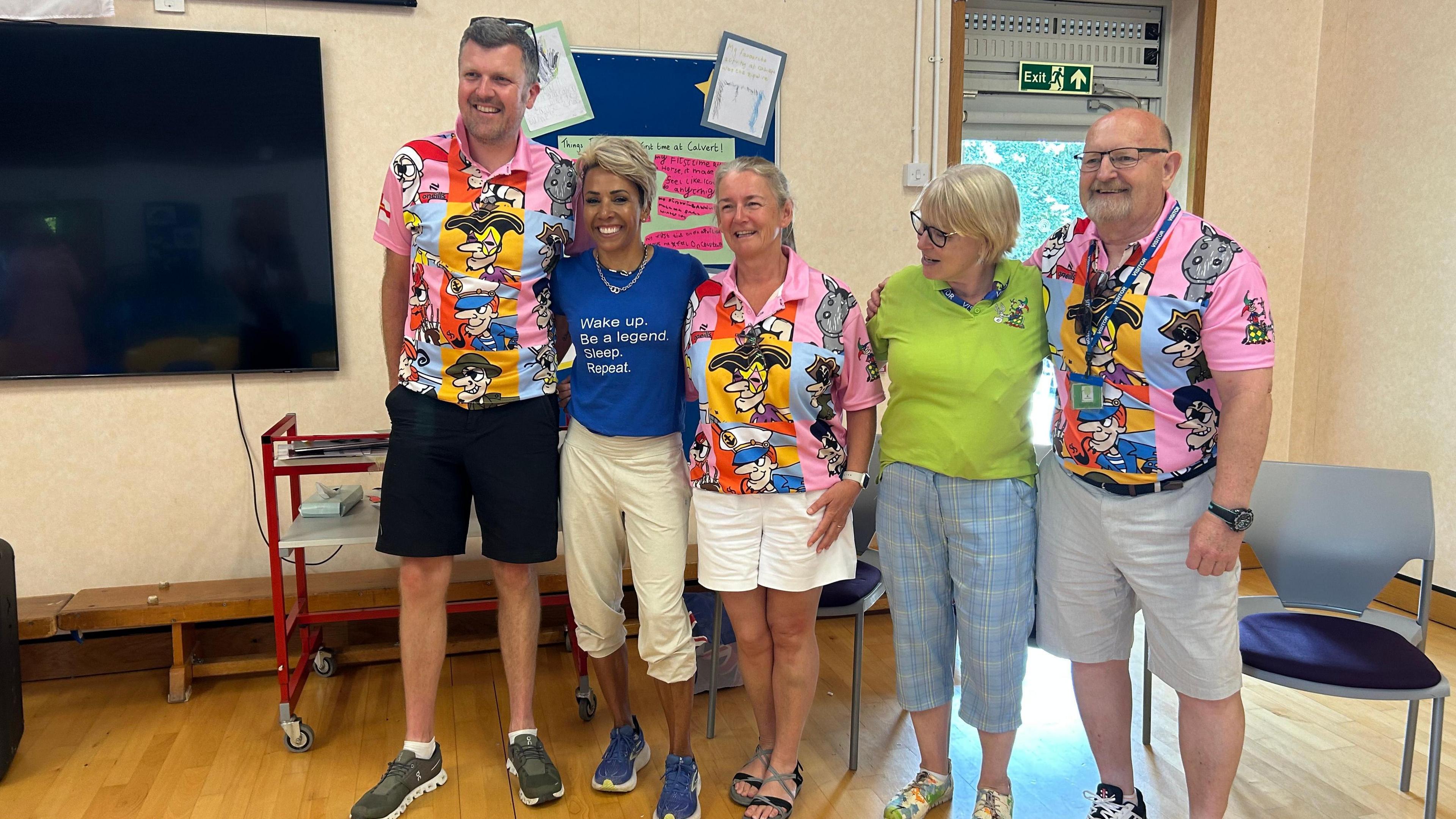 Former Olympian Dame Kelly Holmes on a visit to Le Rondin School on Guernsey. She is wearing a blue T-shirt which reads 'Wake up. Be a legend. Sleep. Repeat'. With her are staff from the school.