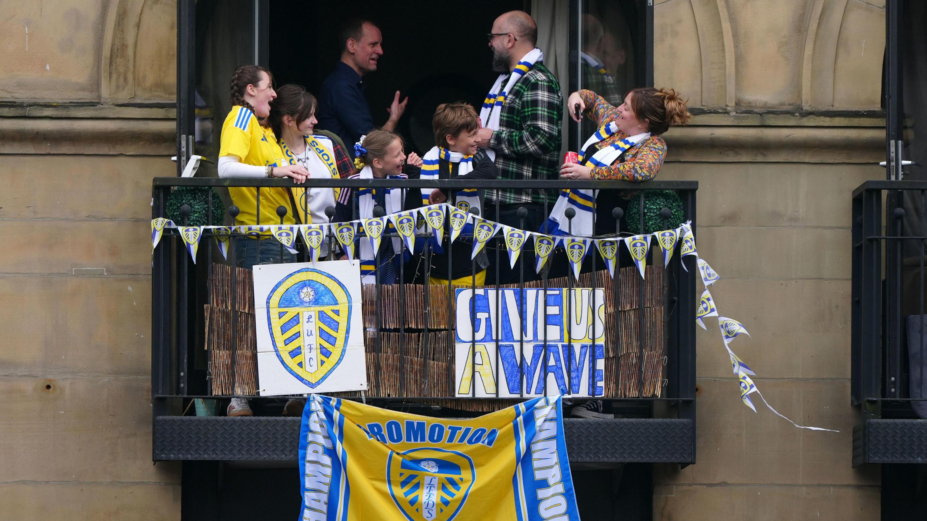 Fans stand on balcony adorned in Leeds United flags 