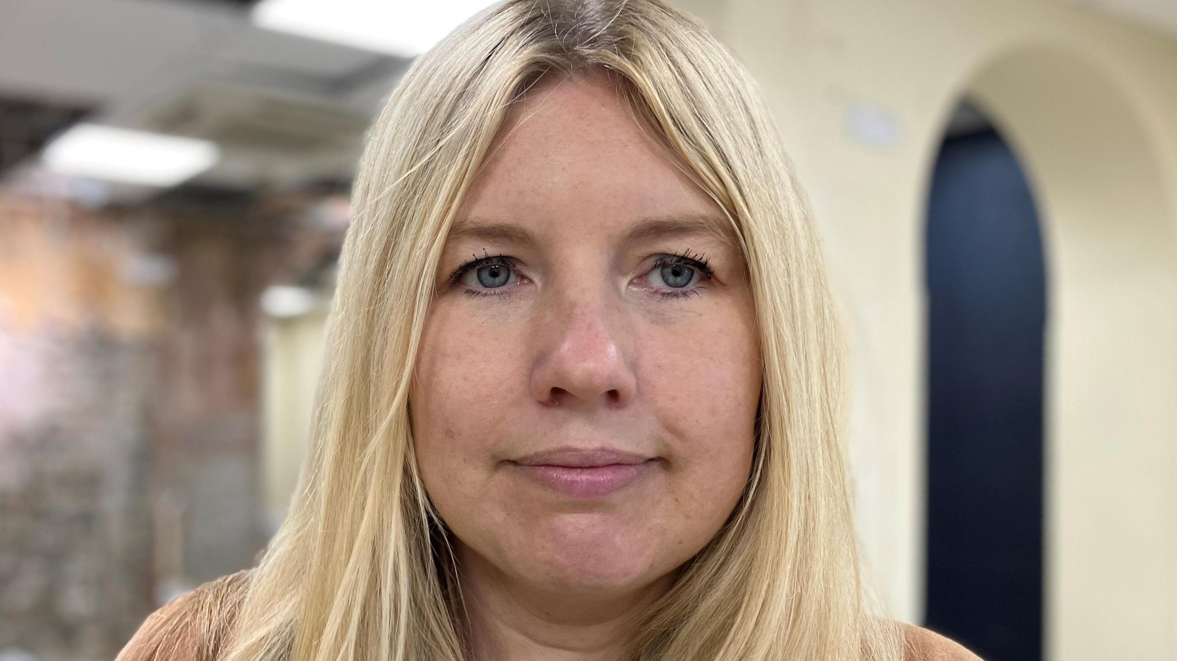 Woman with long blonde hair smiling at camera 