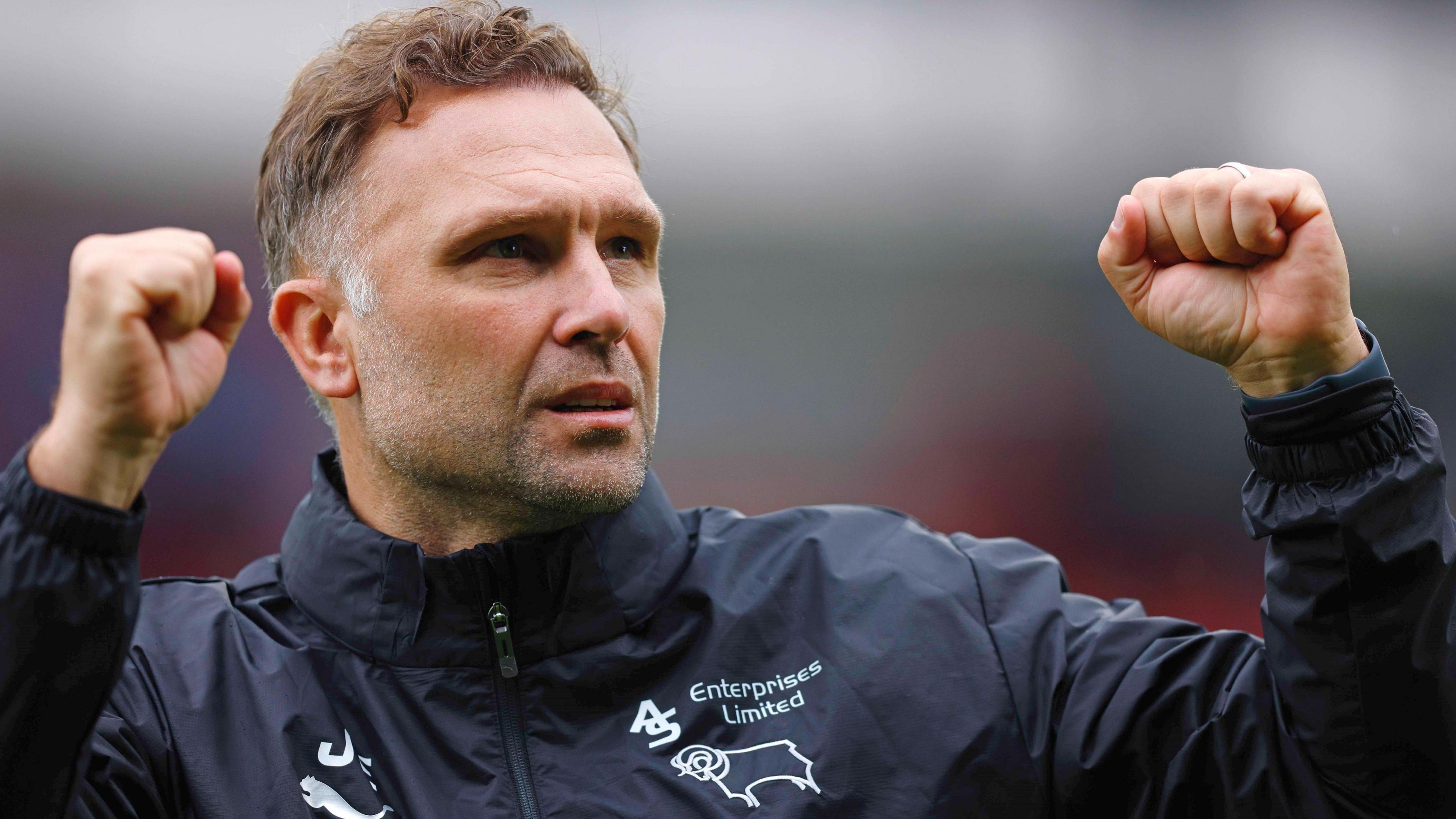 John Eustace celebrates a win as Derby boss with both fists in the air