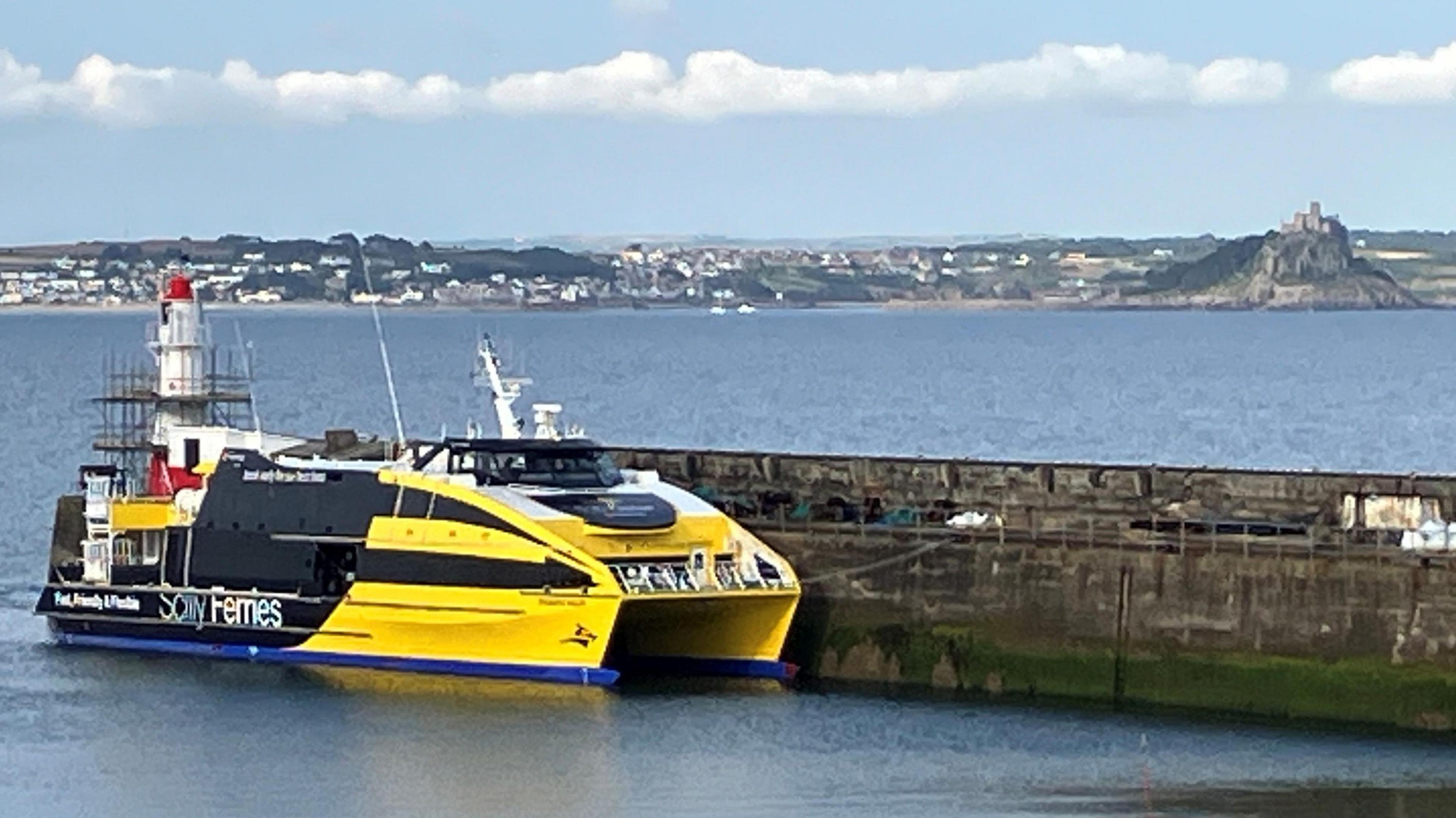 The Atlantic Wolff ferry berthed in Newlyn. It is a yellow and black-liveried catamaran