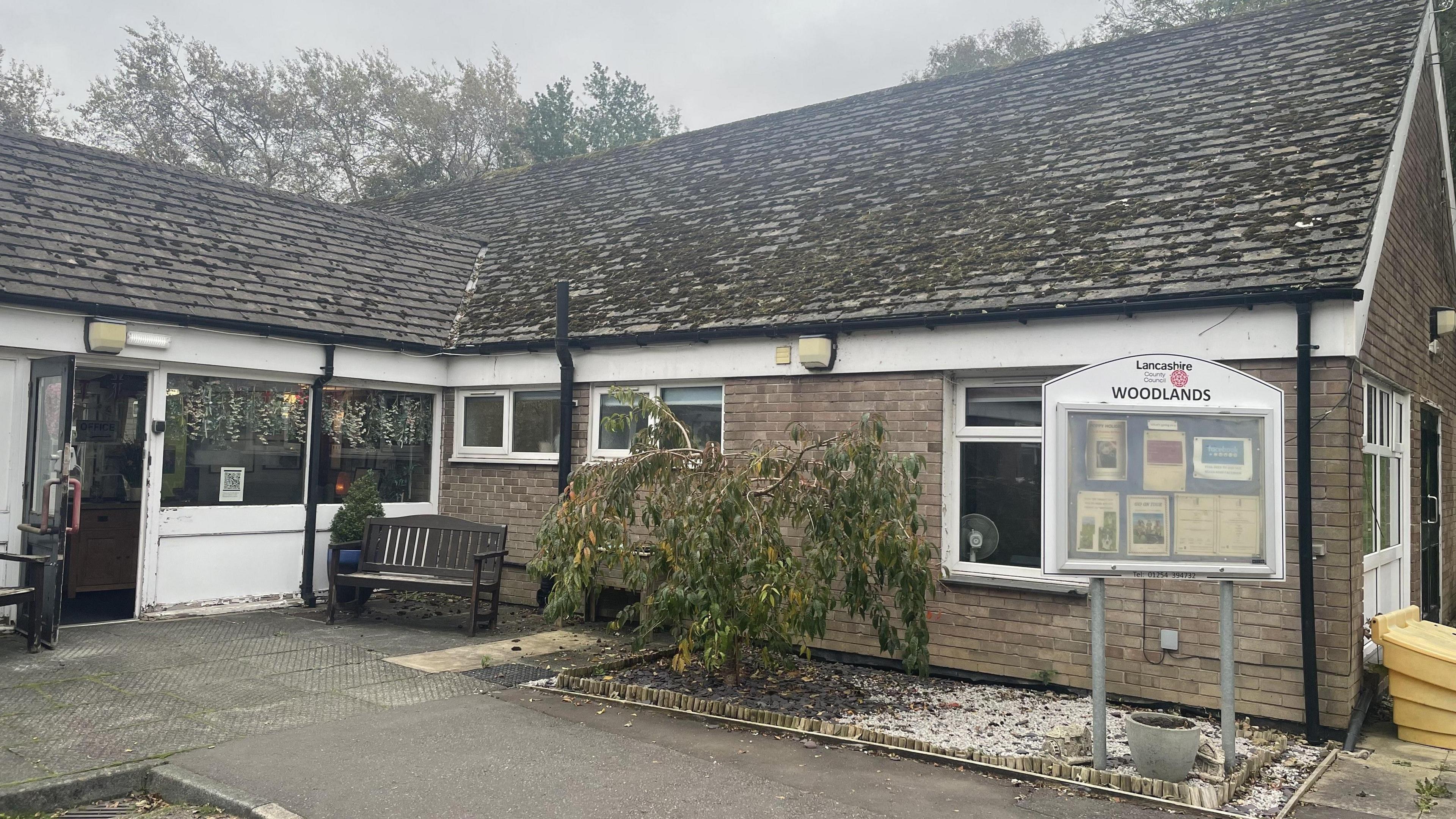 An image of Woodlands Home for Older People. It is a single-storey brick building.