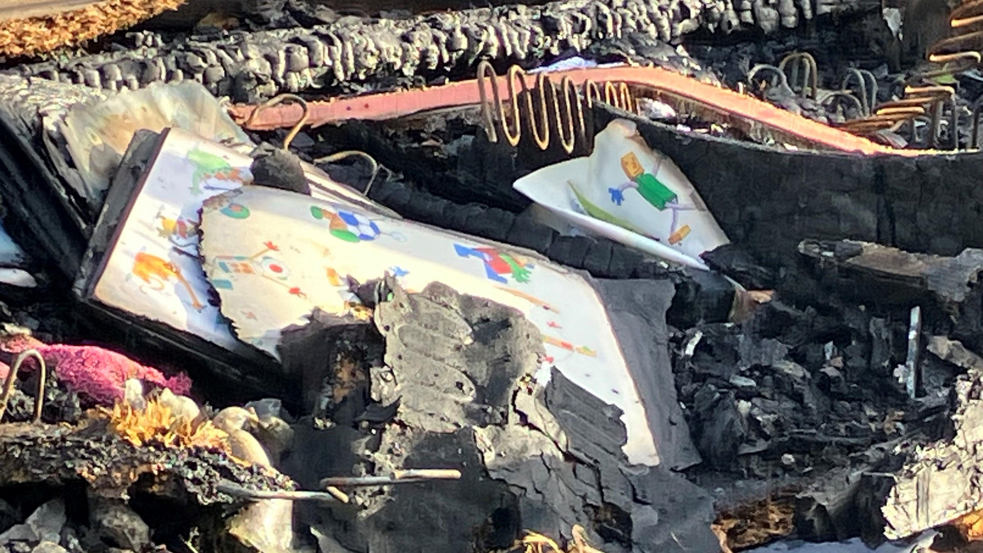 Cartoon figures on tiles or books are the only visible remains of fire debris that surrounds them 