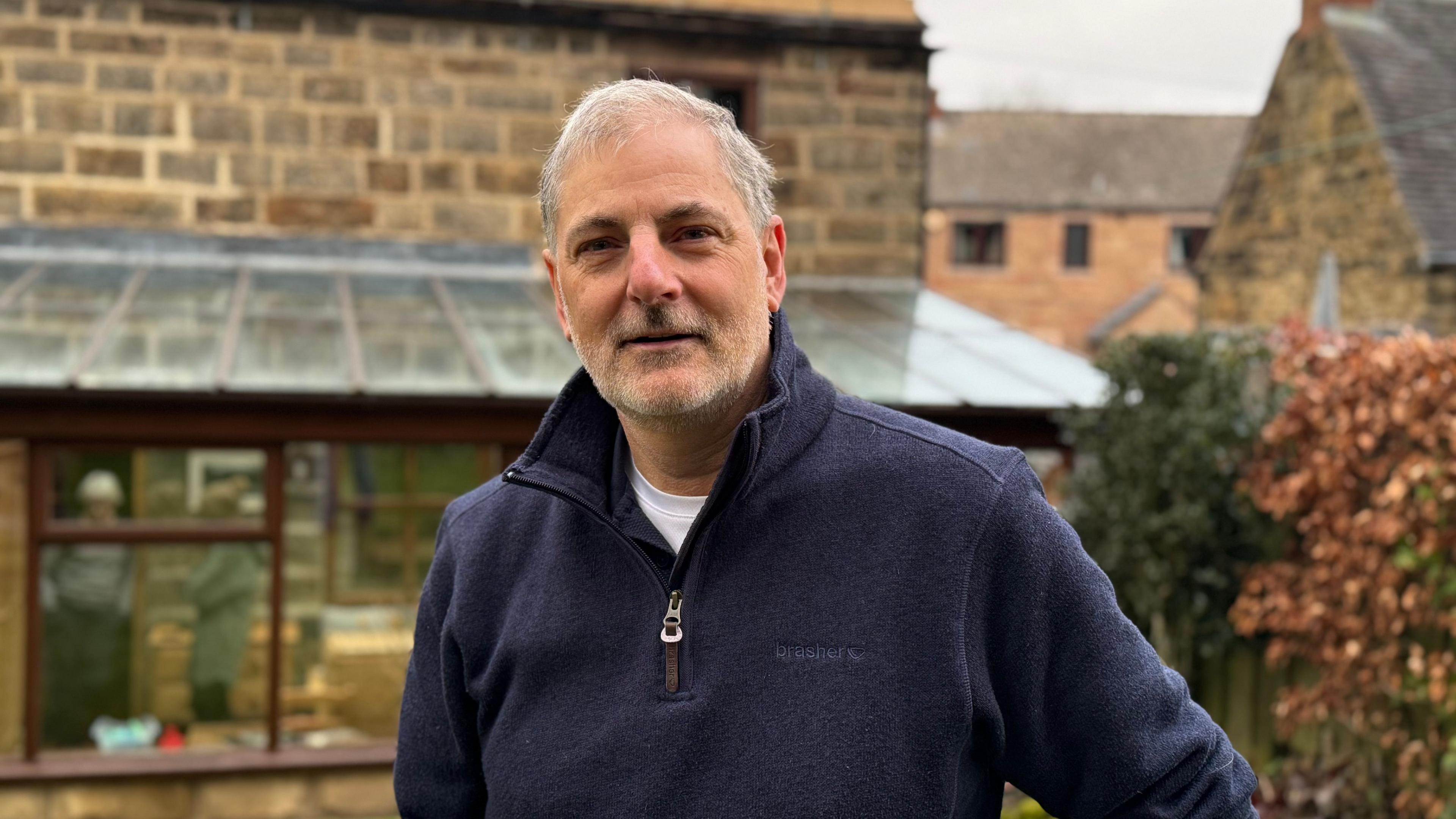 Prof Tony Moore standing in front of his home 