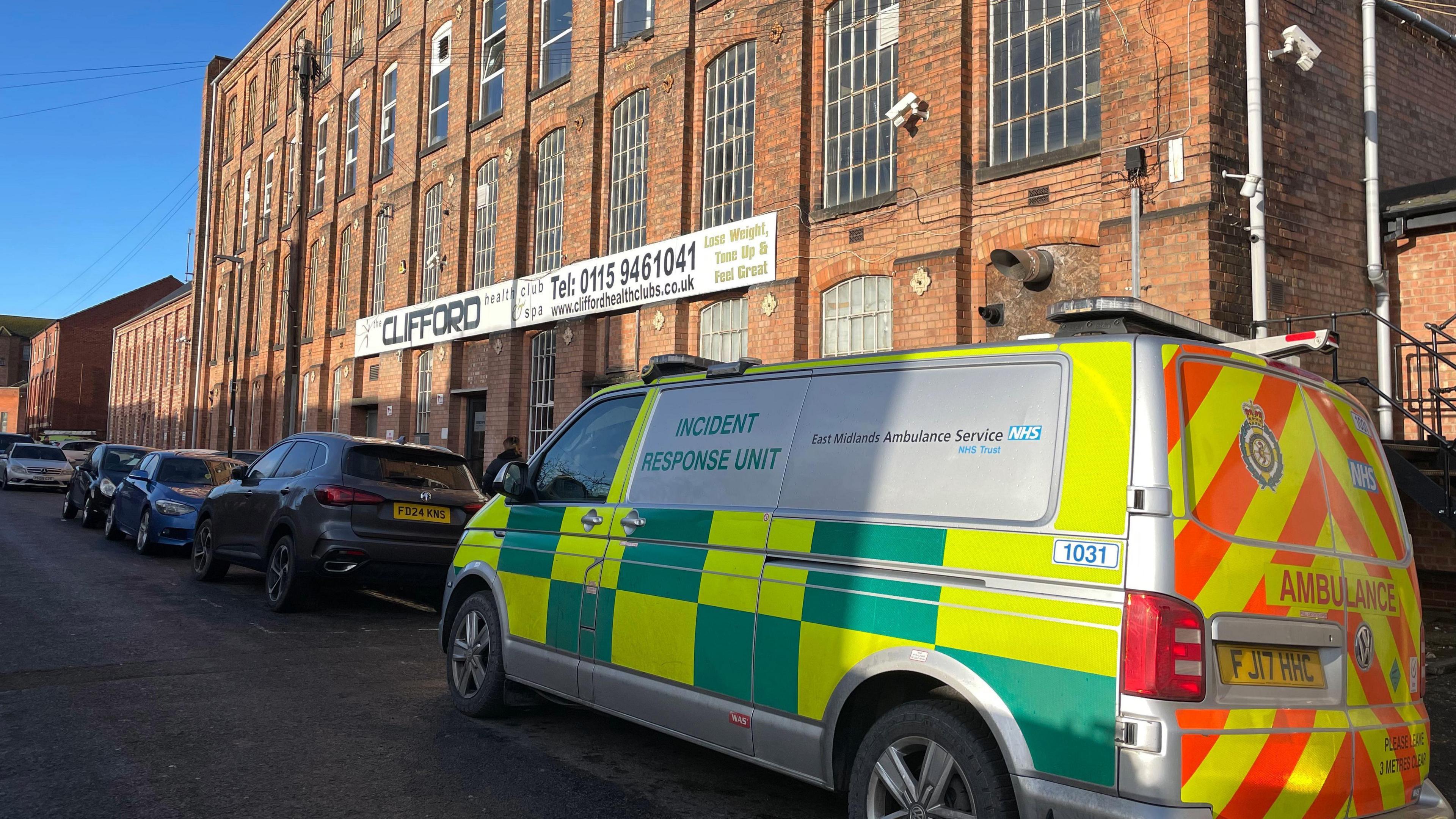 An Incident Response Unit van parked outside Clifford Health Club and Spa, a red brick building.