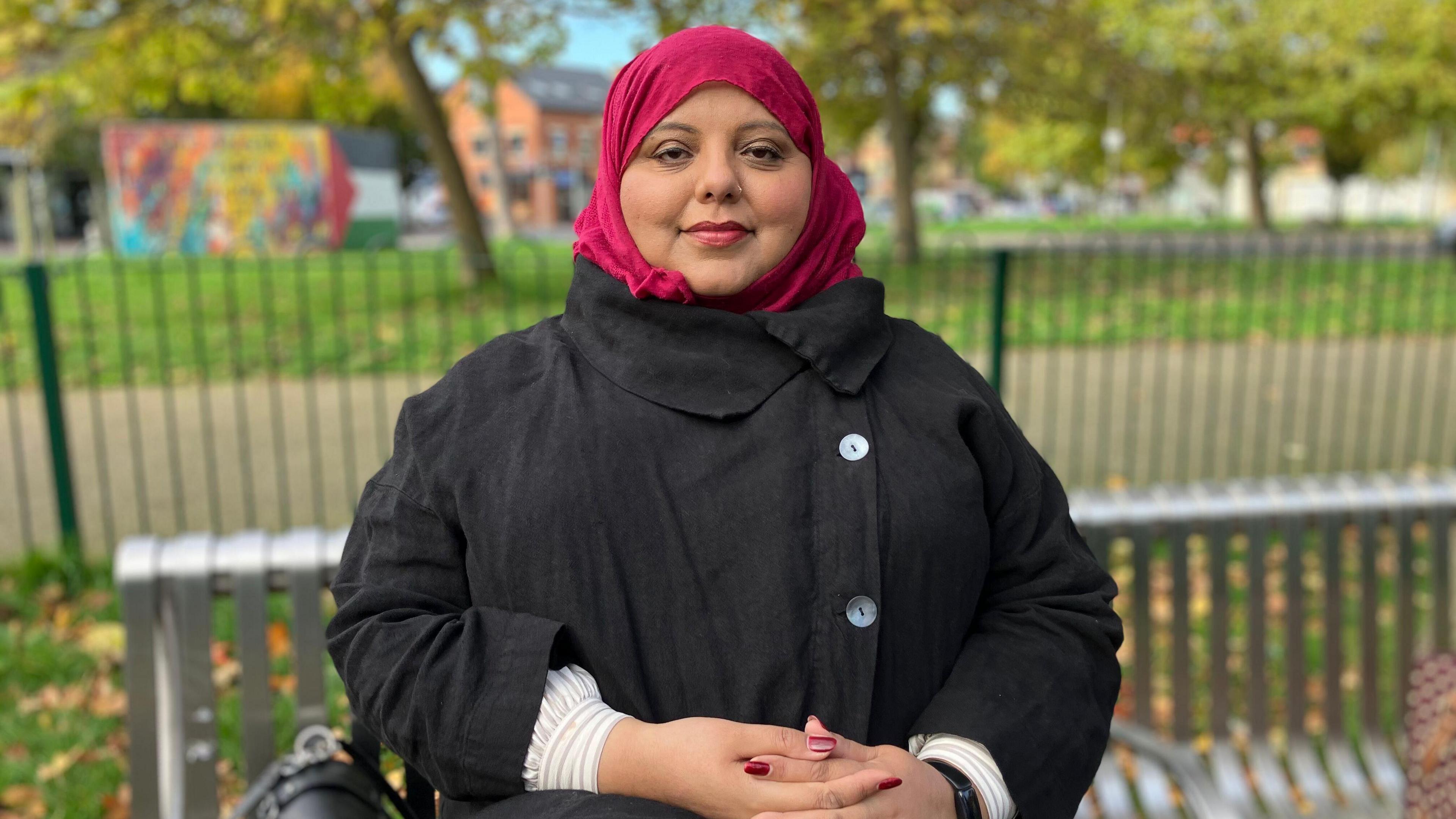 Shaista Aziz sits on a bench in a park just off Cowley Road in Oxford. 