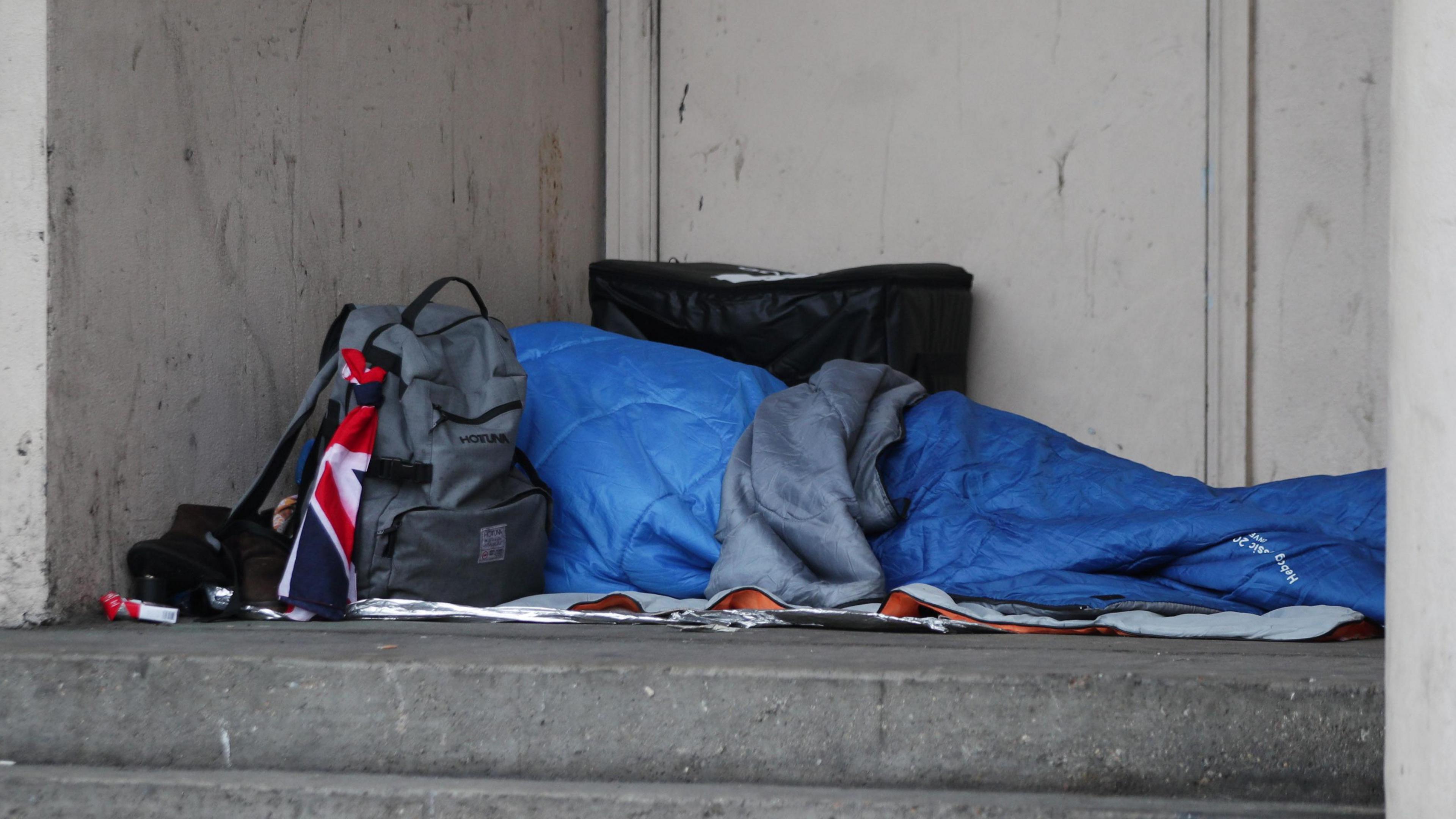 Person sleeping rough on a pavement 