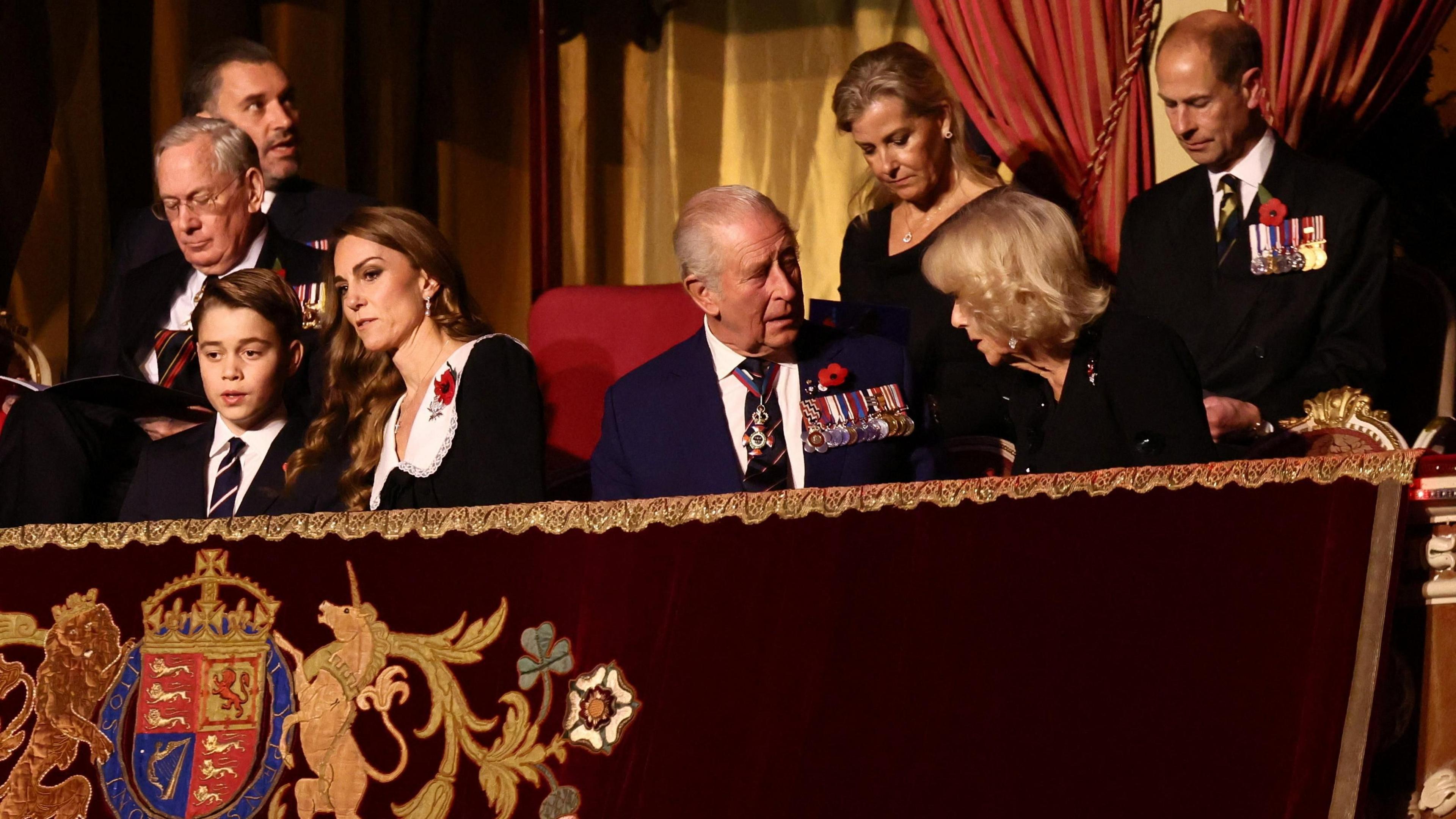 Prince George, Princess Catherine, King Charles and Queen Camilla are pictured sat in the front row of a royal box.