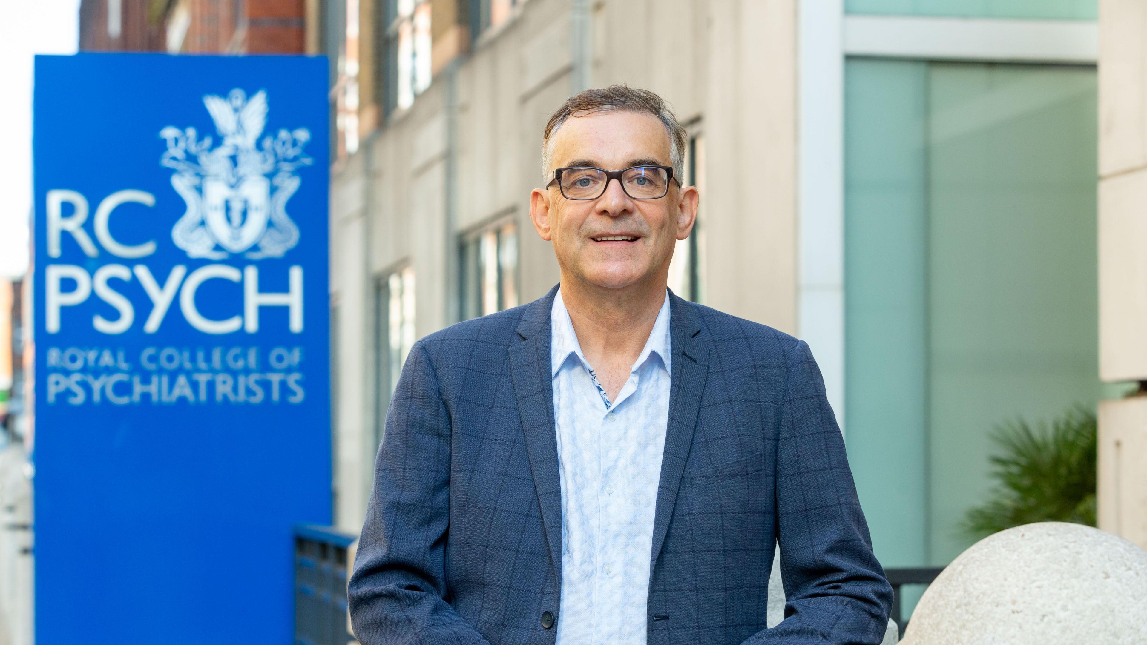 Dr Ulrich Müller-Sedgwick stands in front of the office of the Royal College of Psychiatrists.