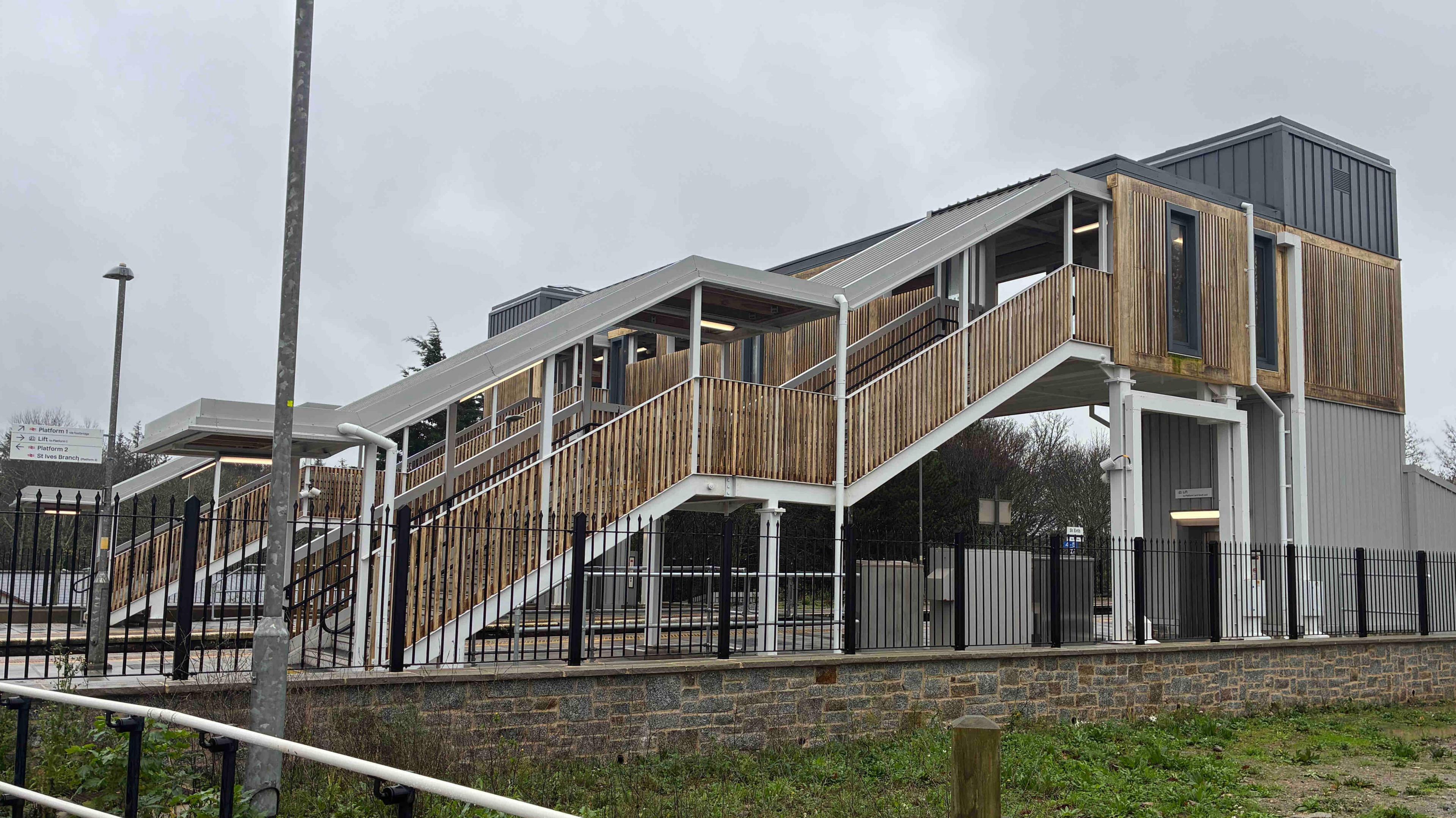 A bridge at a St Erth station in Cornwall allows passengers to get between the platforms. It features a new lift in the main columns and the stairwells have wooden cladding.