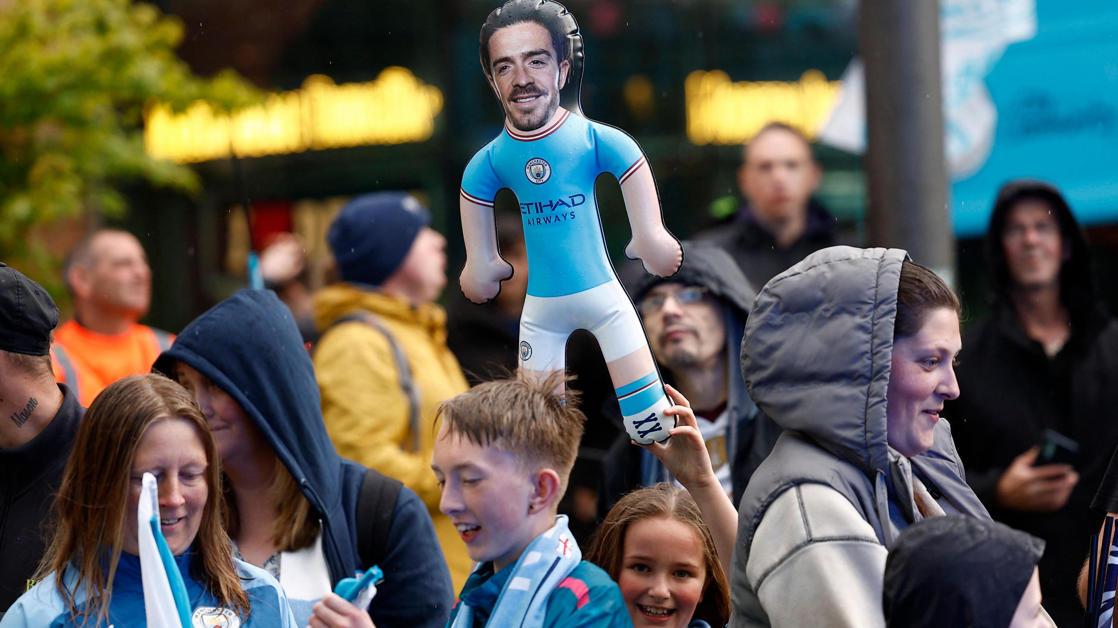 Girl holds a Jack Grealish doll