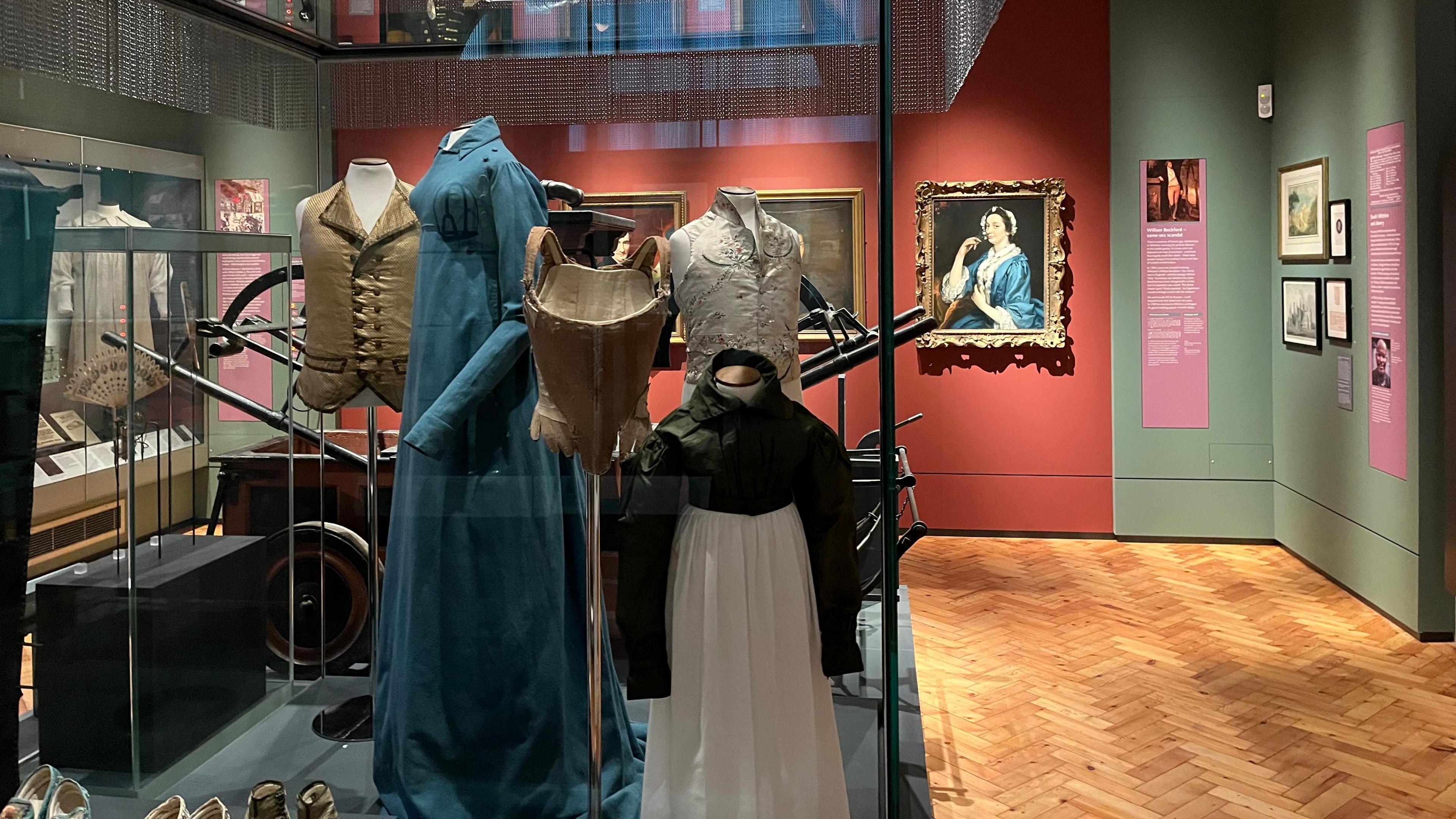 Part of a gallery with historical costume and paintings