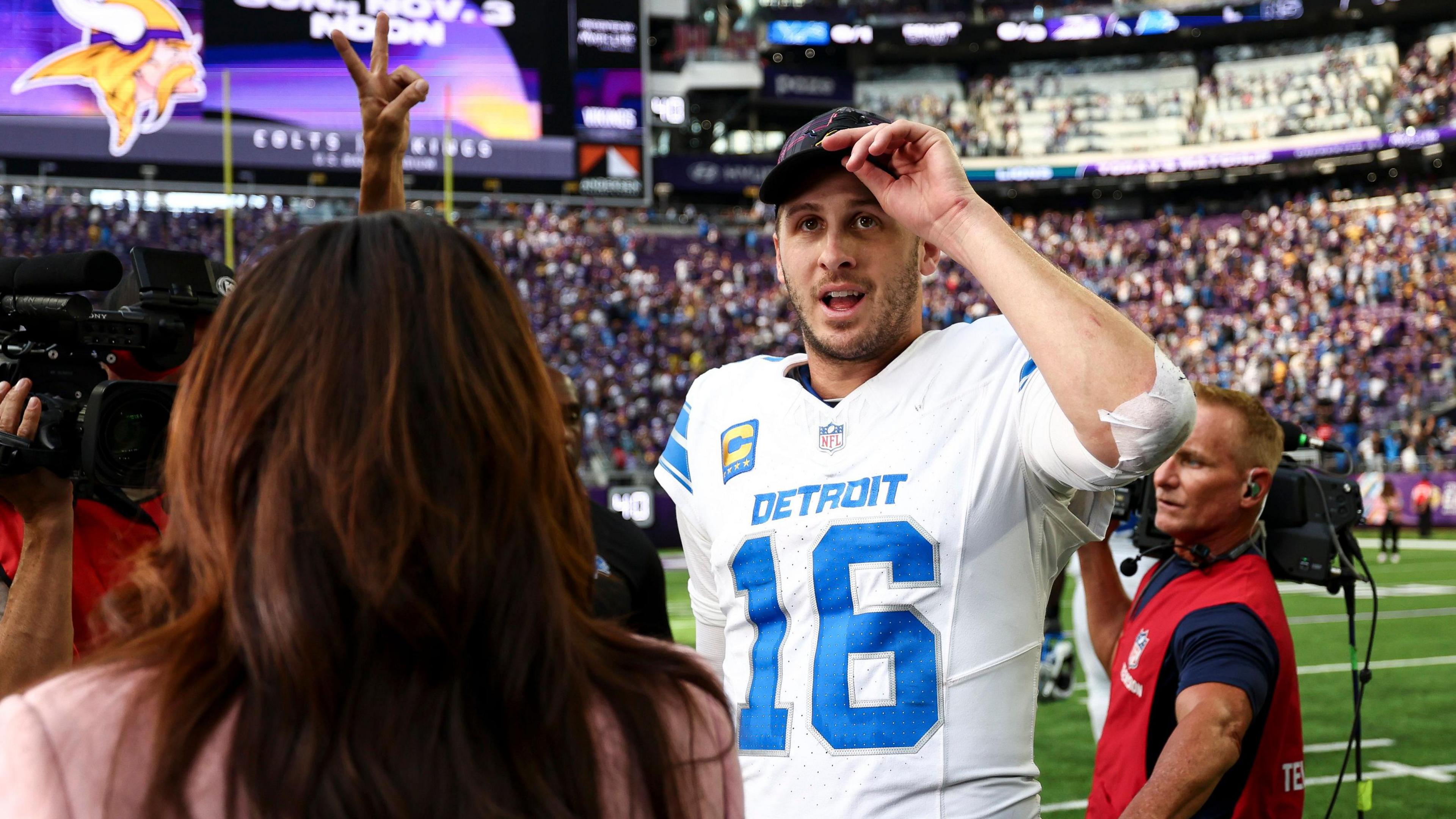 Detroit Lions quarterback Jared Goff talks to reporters on the field after beating the Minnesota Vikings