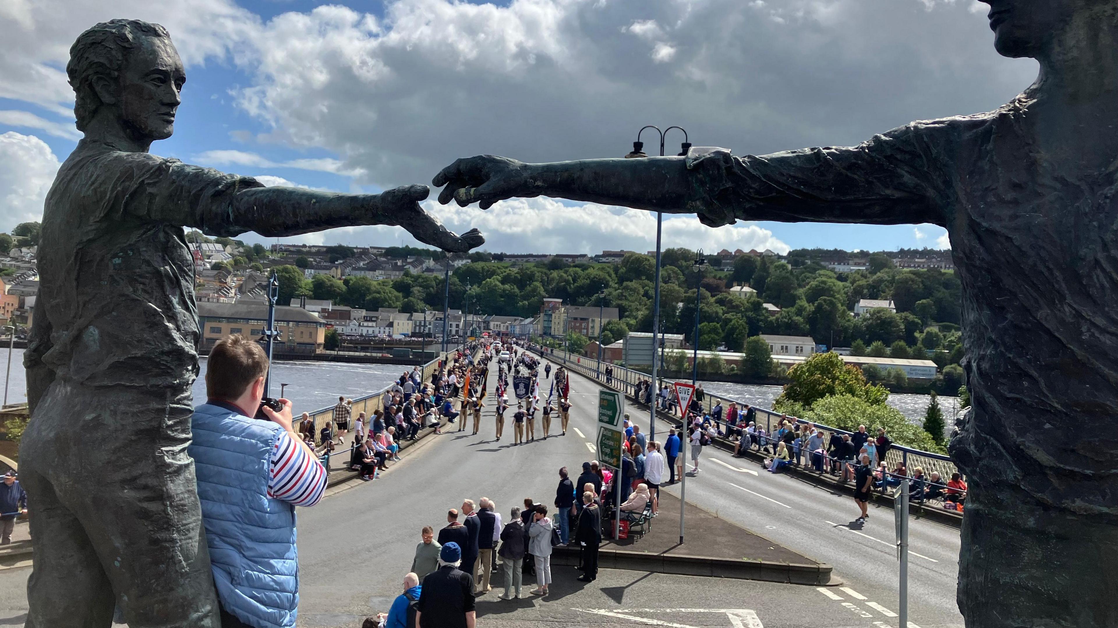 People lined up along the streets to watch the Apprentice Boys of Derry parade. Two statues are in the forefront of the image