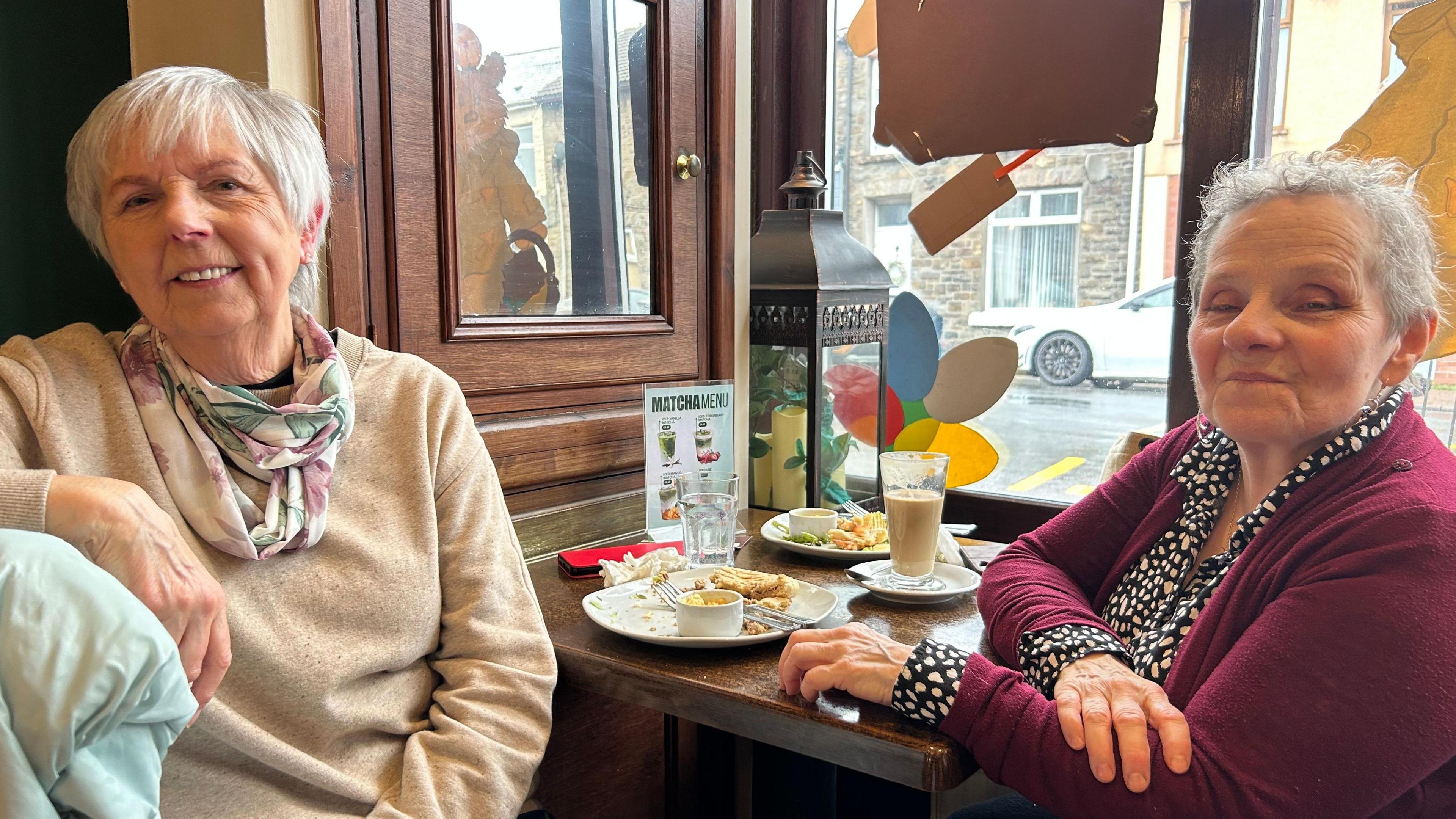 Edna Colwill a Mary Shewring, yn cael paned yng nghaffi Hot Gossip yn Nhreorci