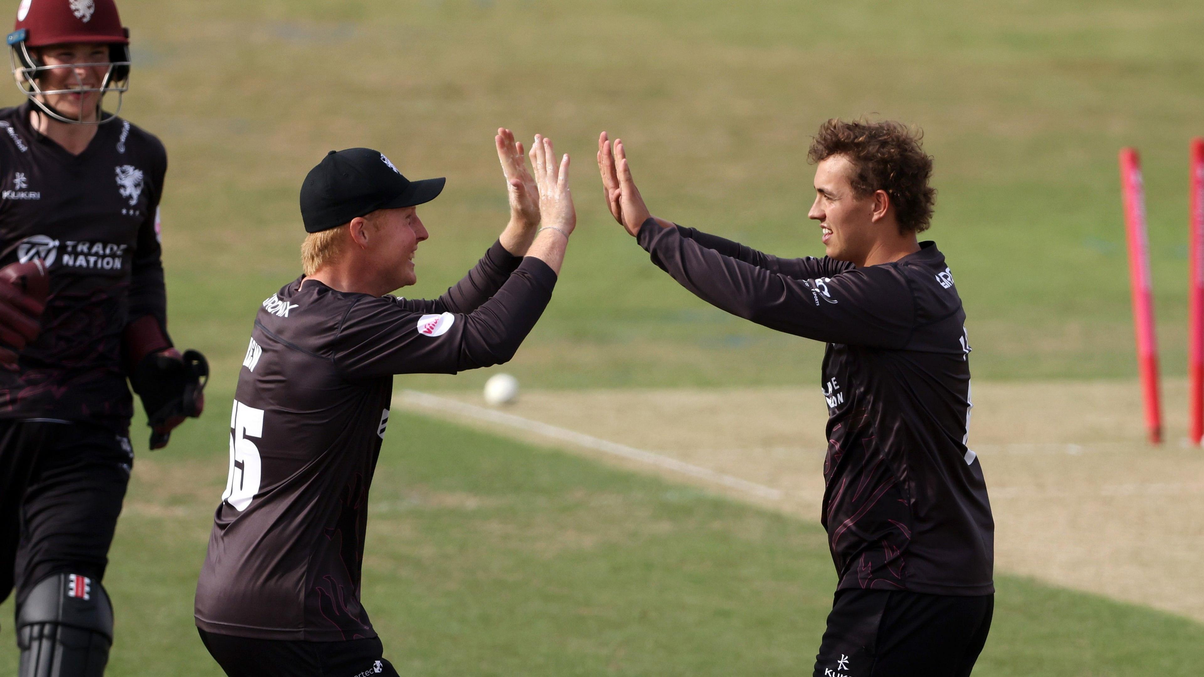 Somerset's Josh Thomas (right) celebrates a wicket with team-mate James Rew at Wantage Road