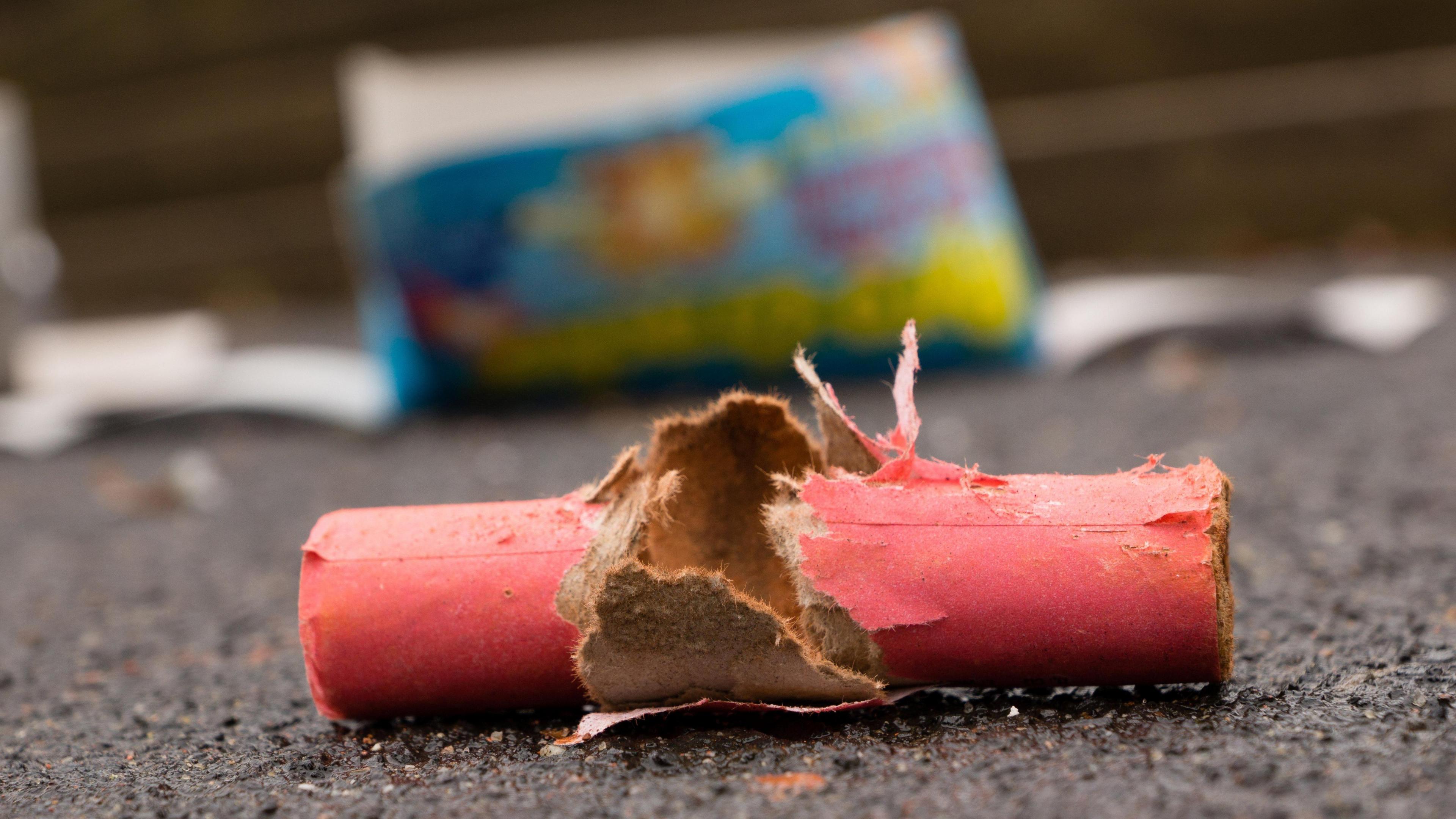 Waste of burnt firecrackers on the street. It's bright red and made of cardboard.