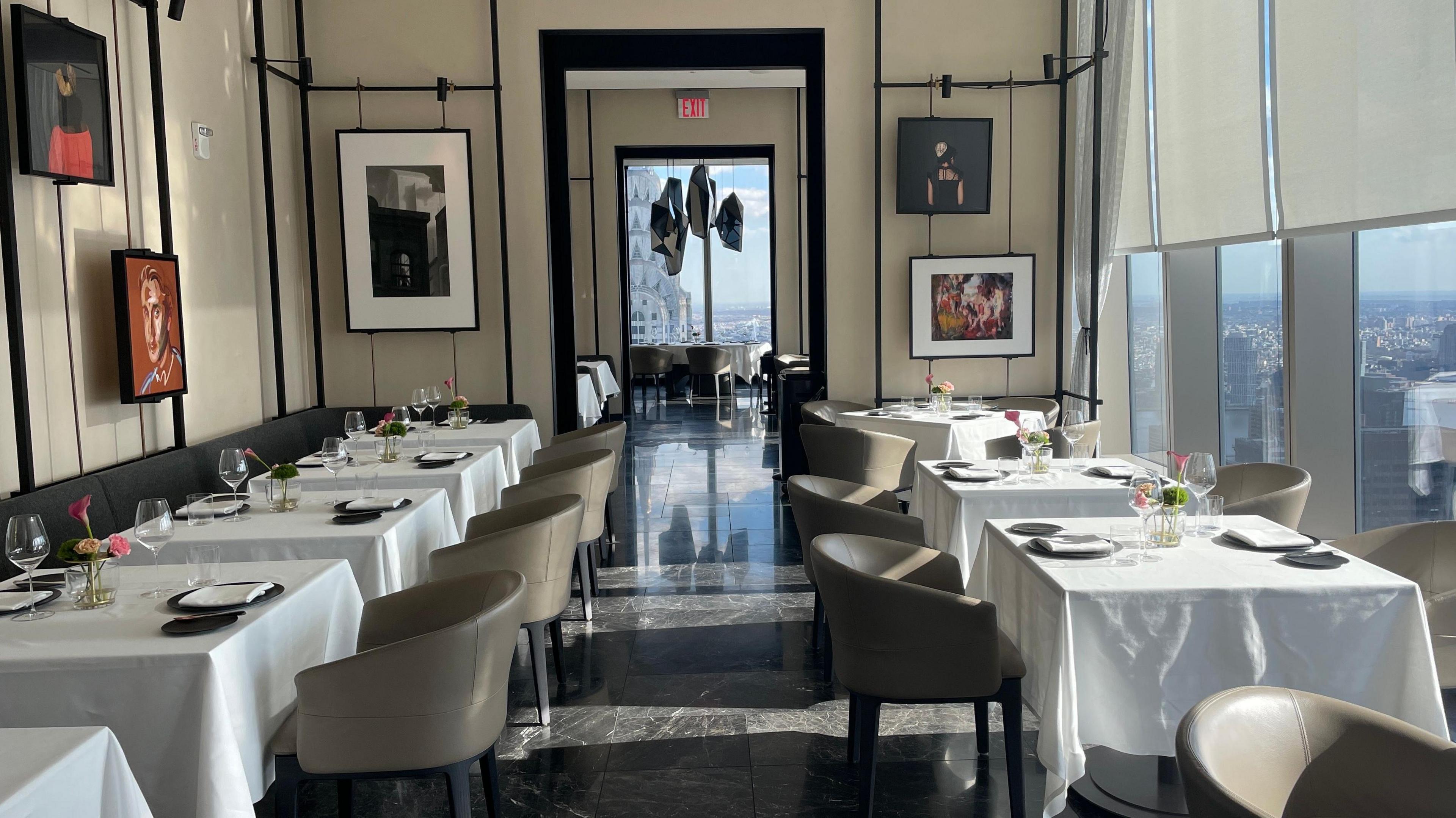 A row of tables and chairs with glasses and plates on top of them at American Express' Centurion New York venue