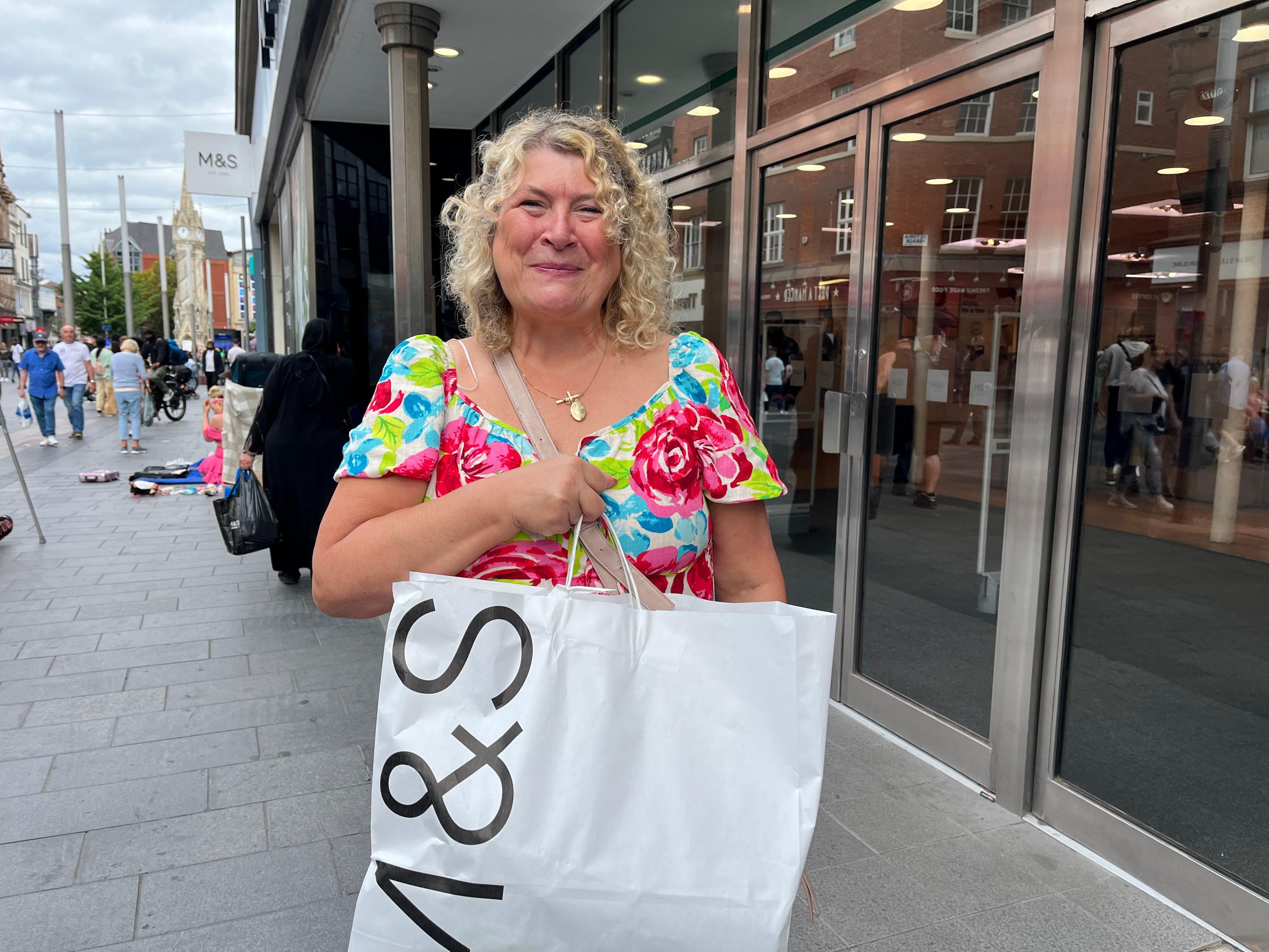 A woman carrying her shopping from M&S