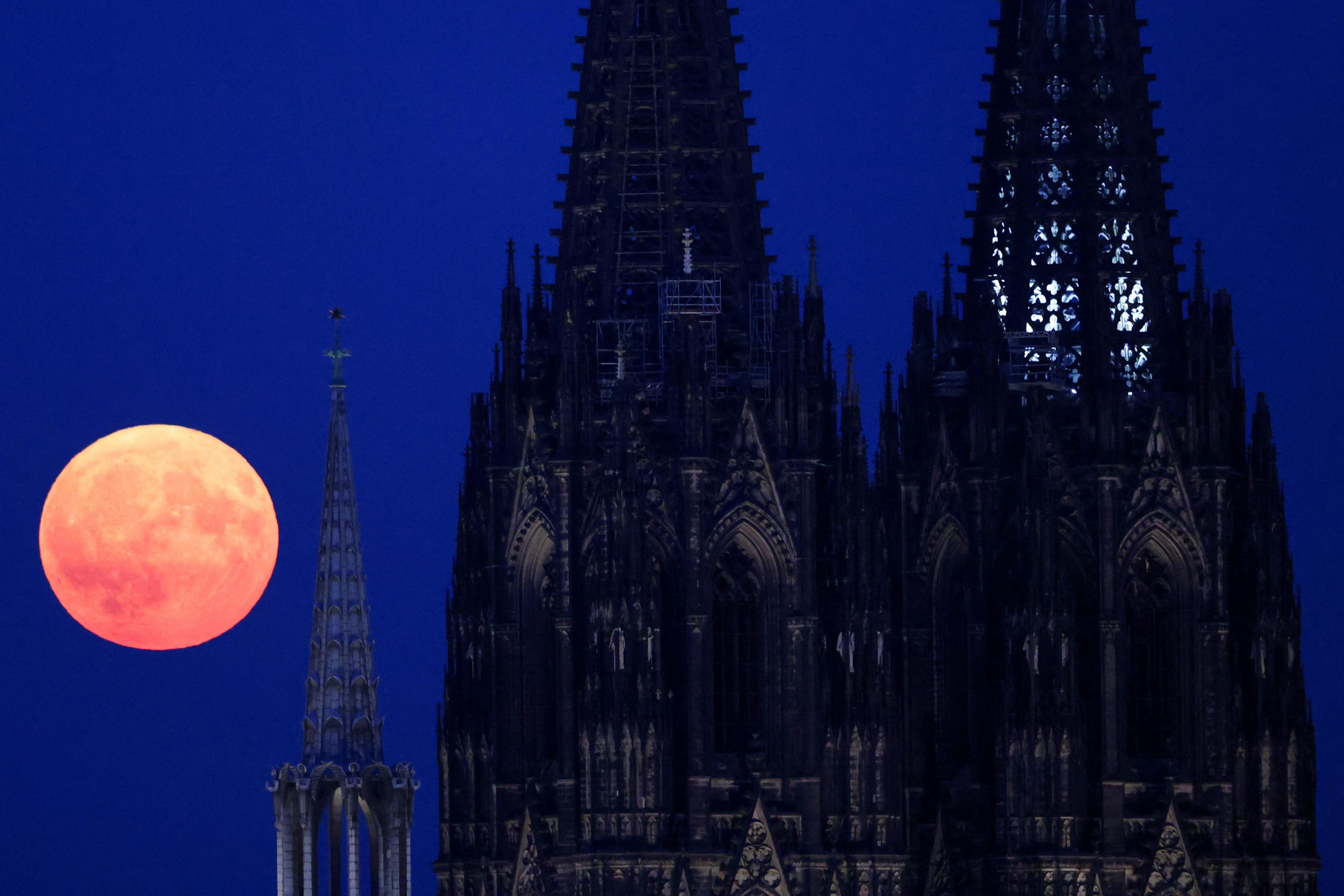 Cologne Cathedral in Germany with the supermoon next to it