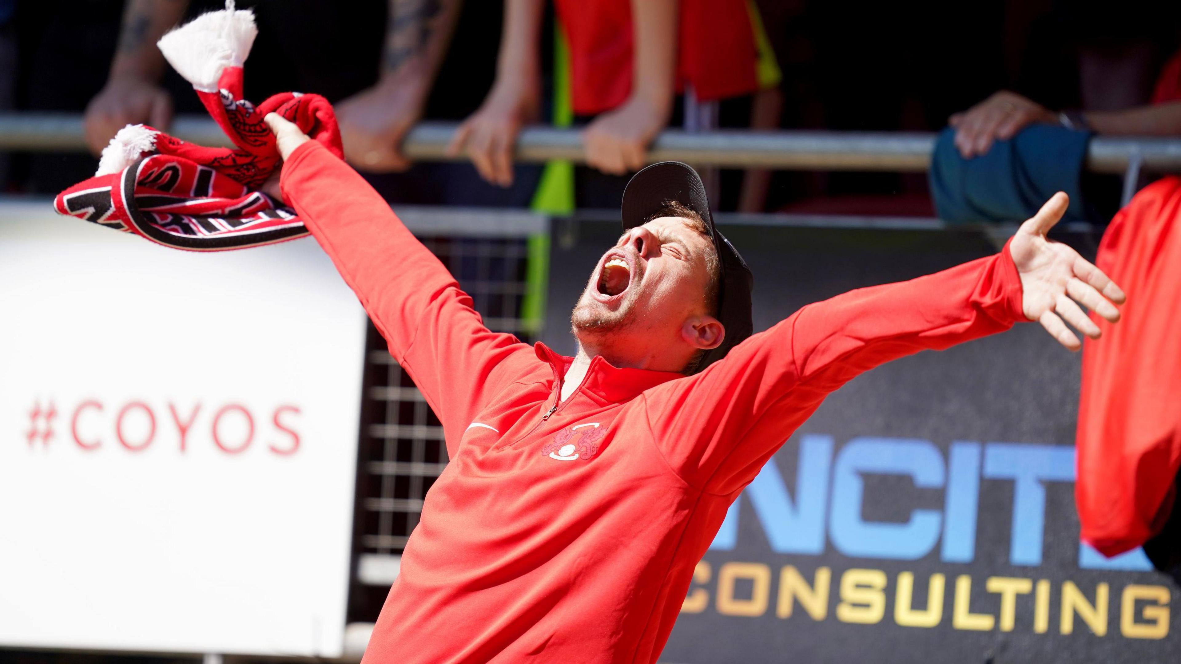 A Leyton Orient fan celebrates in the crowd