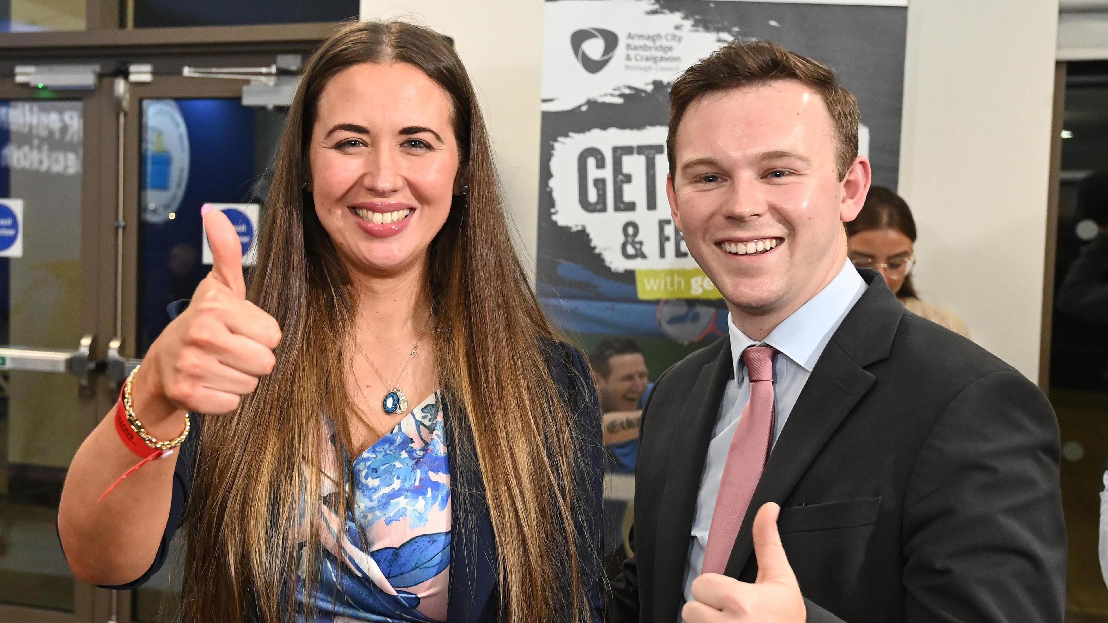 Sorcha Eastwood, left, smiling and giving a thumbs up beside Eoin Tenneyson, also smiling and giving a thumbs up