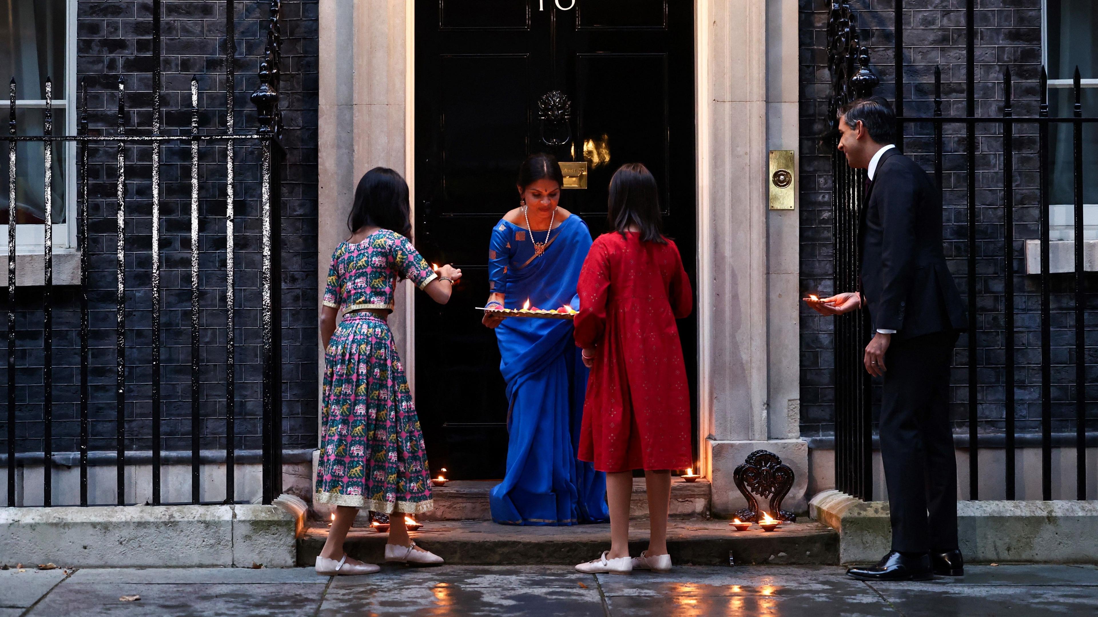 Rishi Sunak with his wife Akshata Murty and their daughters Anoushka and Krishna putting candles outside of No 10 to mark Diwali 