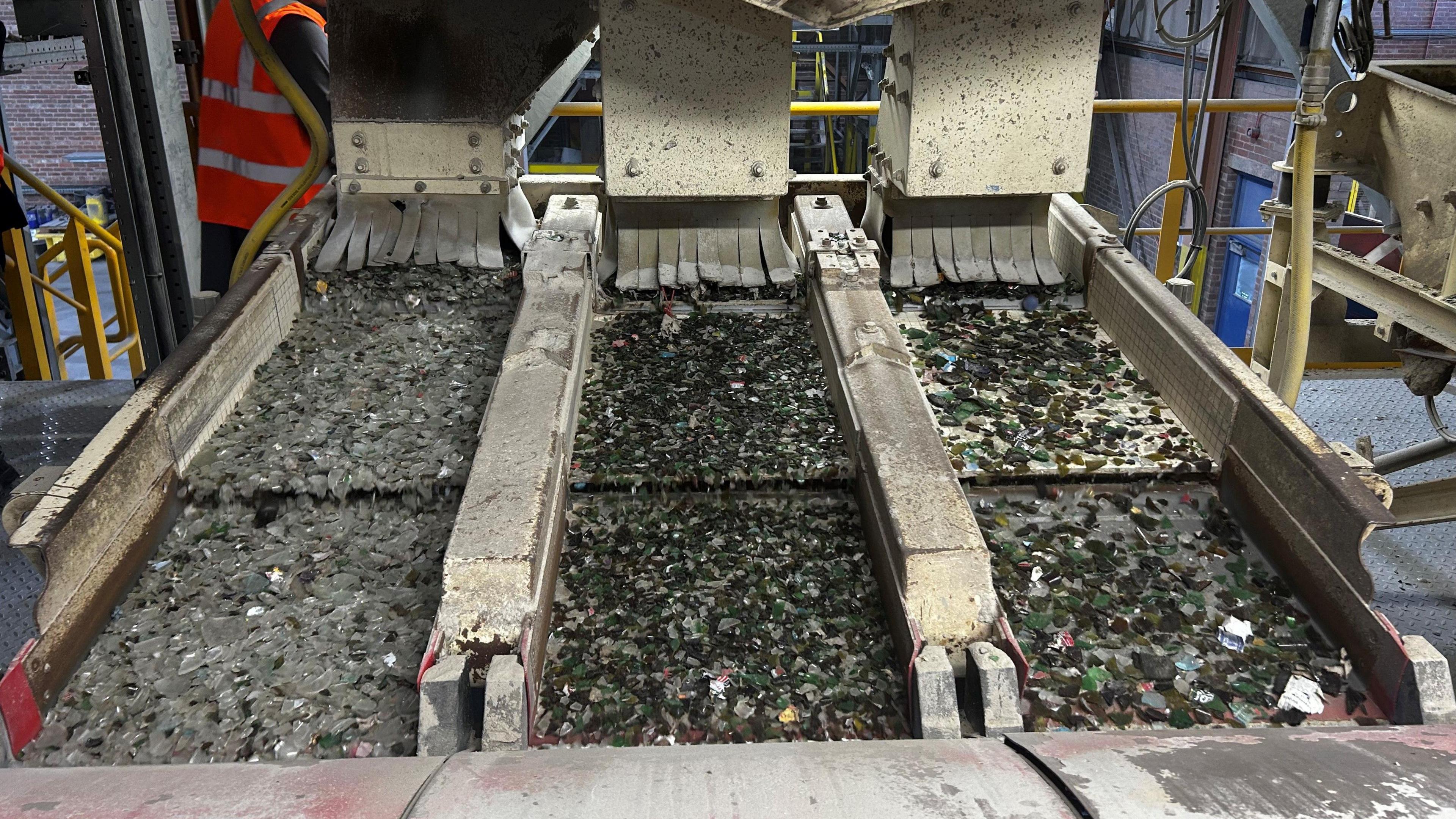 Different coloured glass being separated on conveyor belts